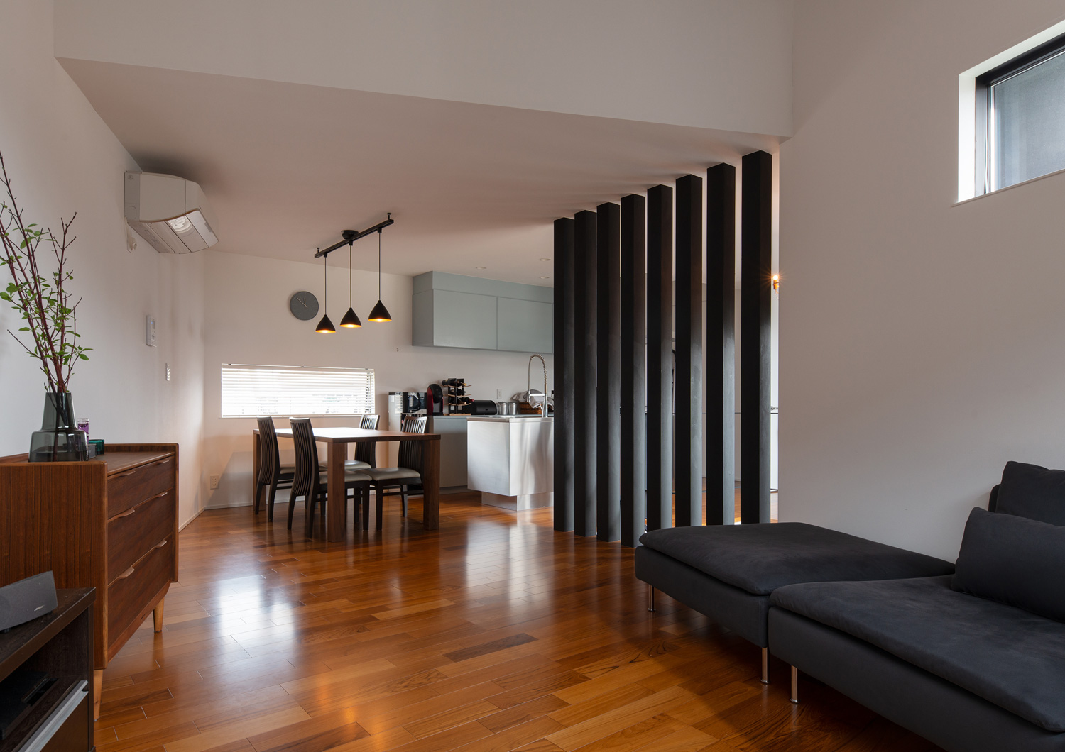 黒のソファーが置かれたフローリングのLDK・デザイン住宅 注文住宅・デザイン住宅建築実例_『CASE621 対角線上の家』_LDK