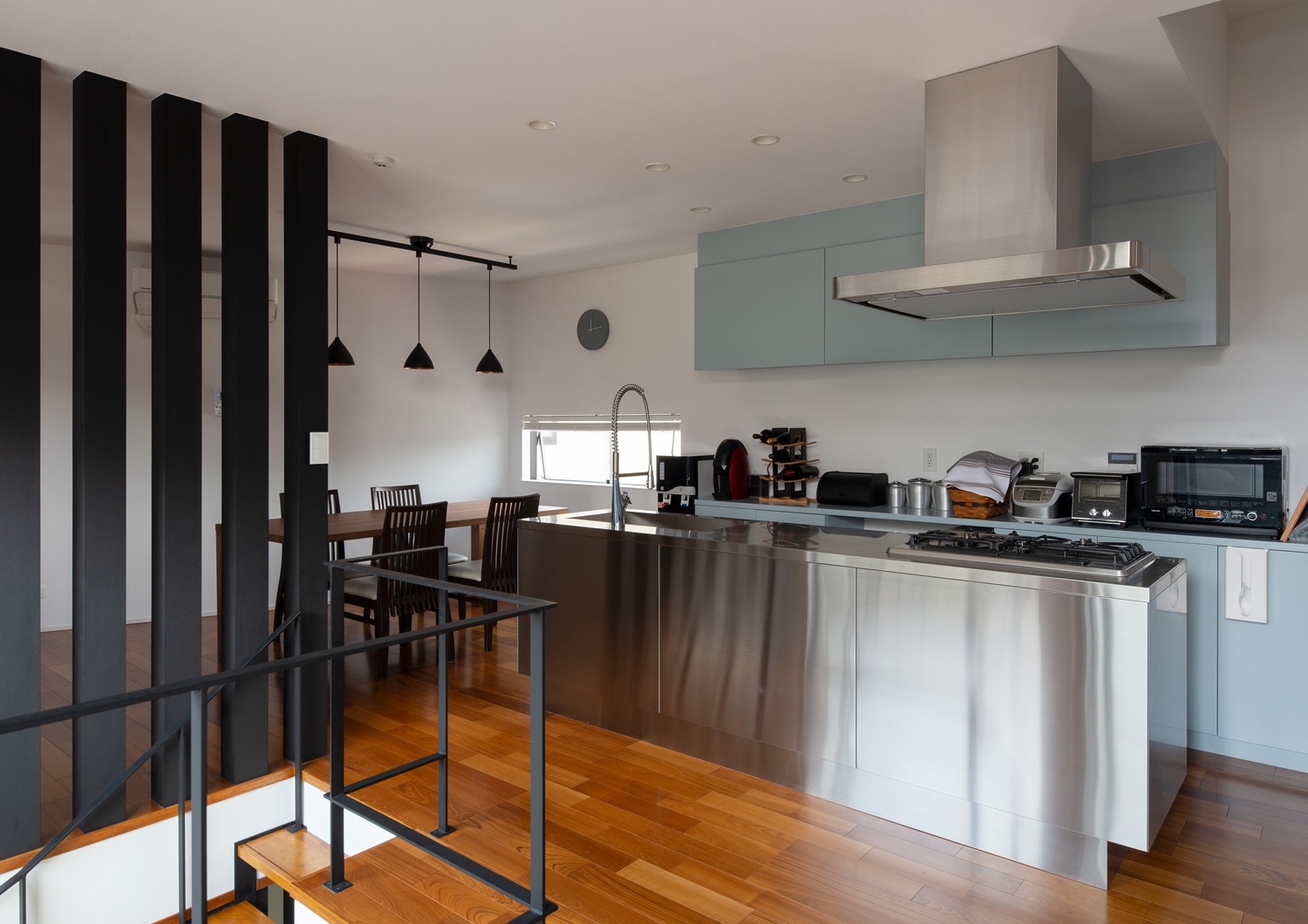 フローリングのフロアにある、ステンレスのアイランドキッチン・デザイン住宅 注文住宅・デザイン住宅建築実例_『CASE621 対角線上の家』_LDK