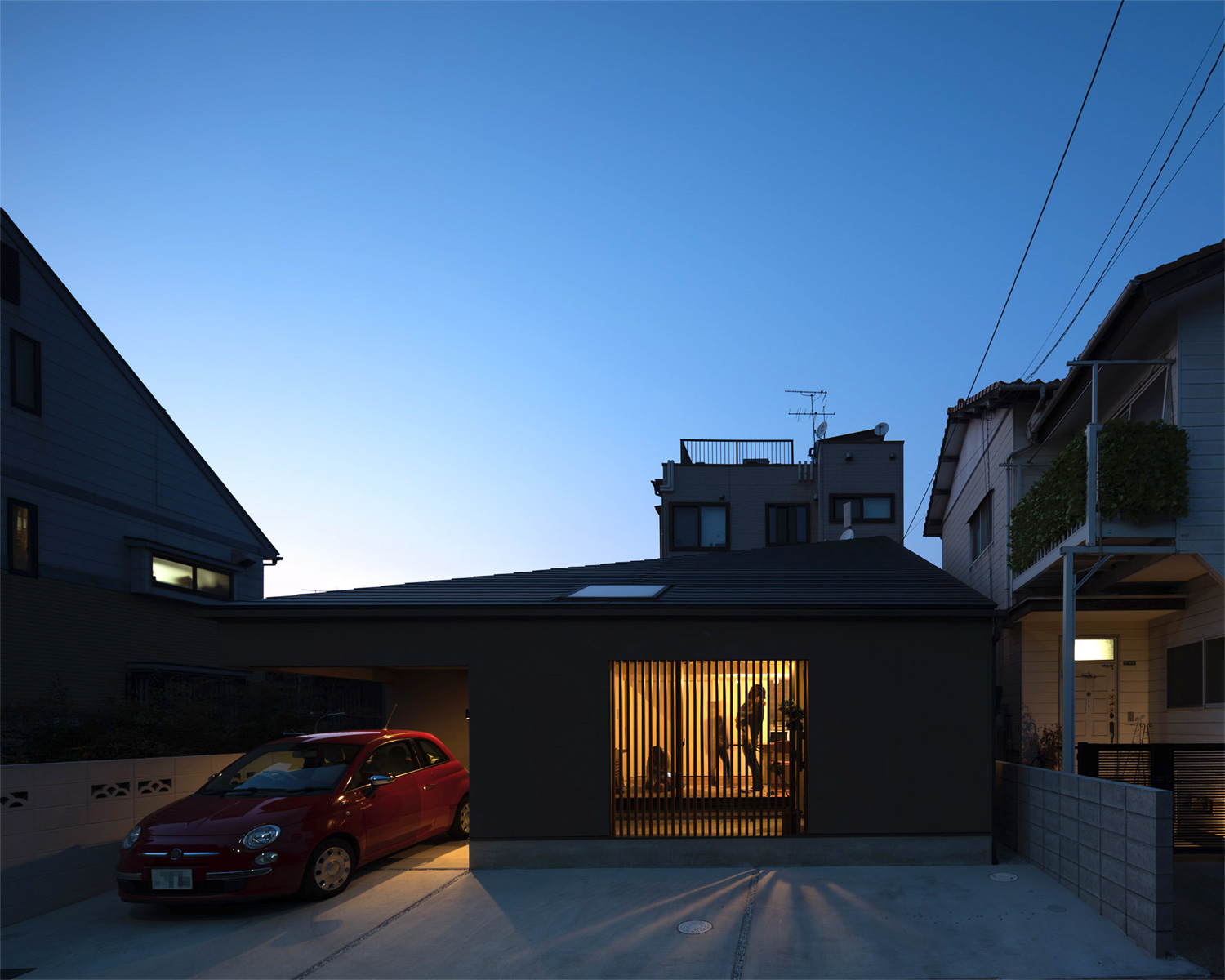 ルーバーから光が漏れる、赤い車が一台止められた平屋住宅・デザイン住宅 注文住宅・デザイン住宅建築実例_『CASE622 fit』_外観