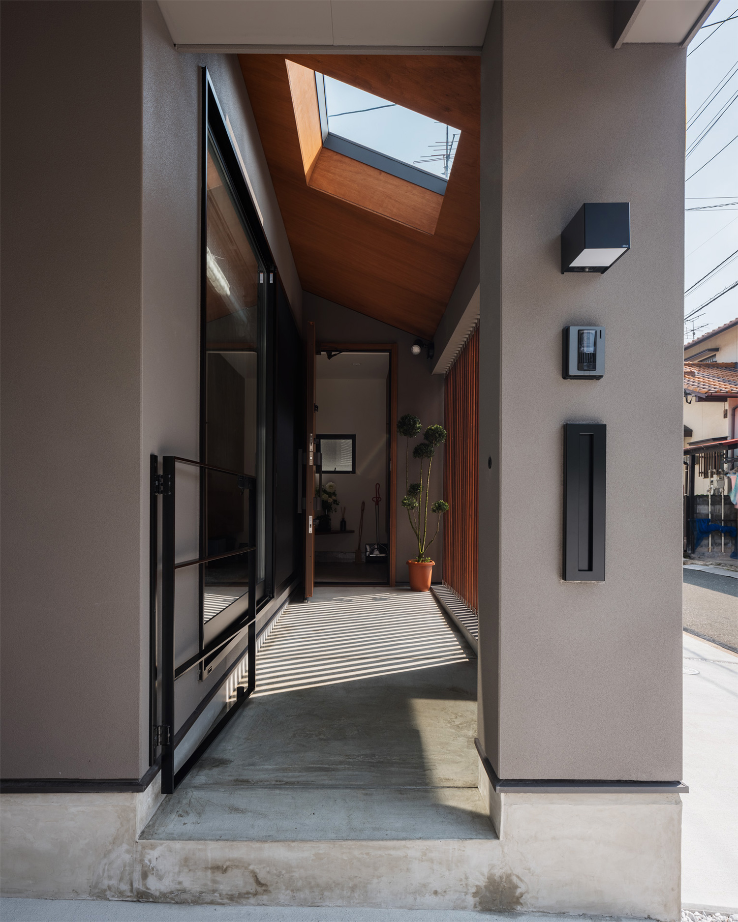 天窓がついており、ルーバーの目隠し壁が立てられた玄関アプローチ・デザイン住宅 注文住宅・デザイン住宅建築実例_『CASE622 fit』_中庭