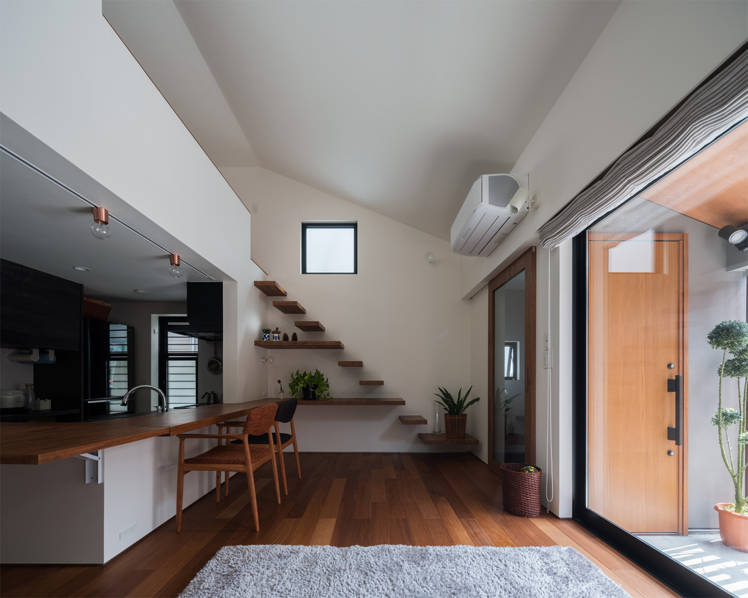 玄関アプローチの様子が見える大きな窓が取り付けられたフローリングにグレーのカーペットが敷かれたLDK・デザイン住宅 注文住宅・デザイン住宅建築実例_『CASE622 fit』_LDK