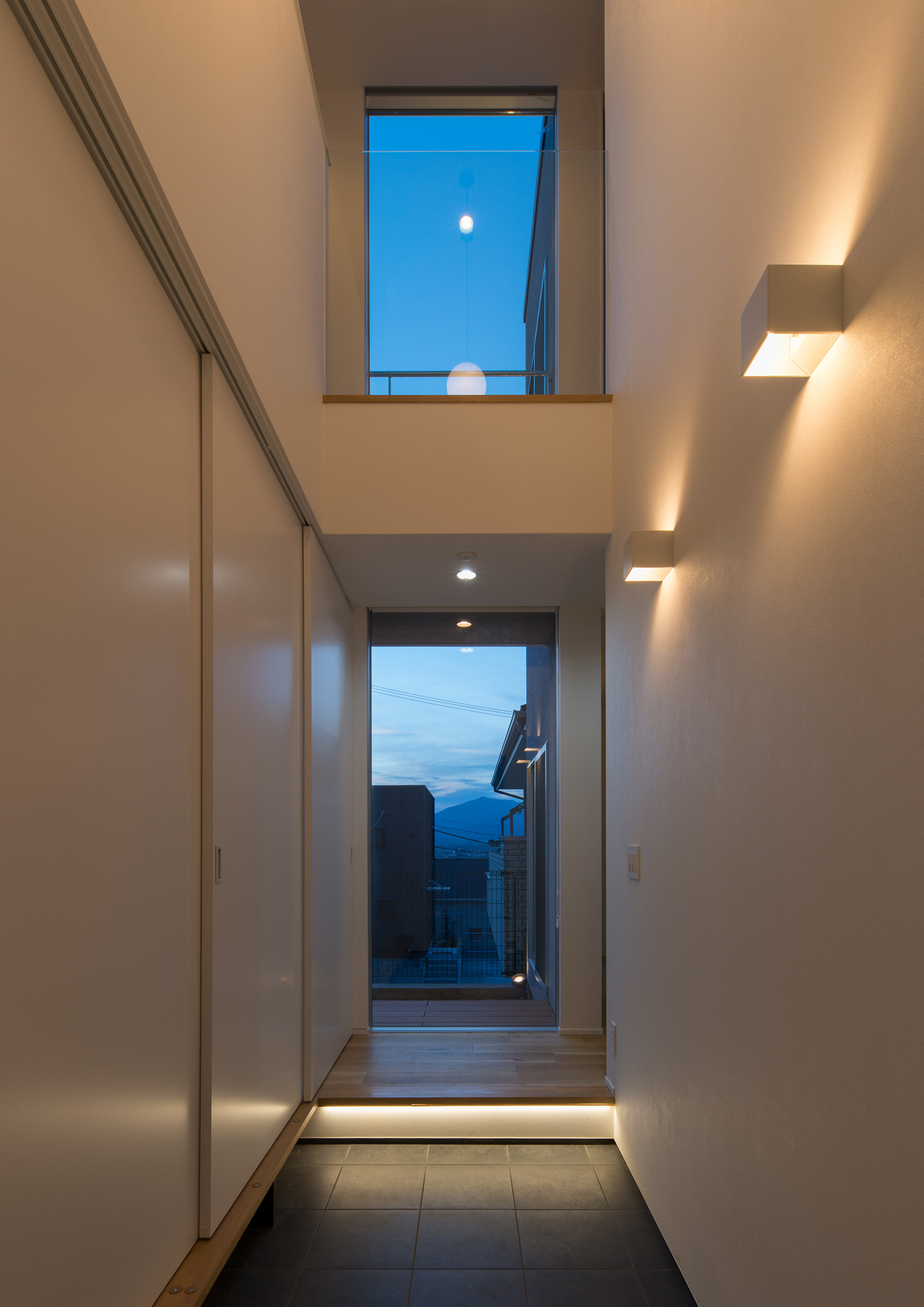 壁に間接照明が取り付けられた、正面に窓がある吹き抜けの玄関・デザイン住宅 注文住宅・デザイン住宅建築実例_『CASE624 『7:3の家』』_玄関