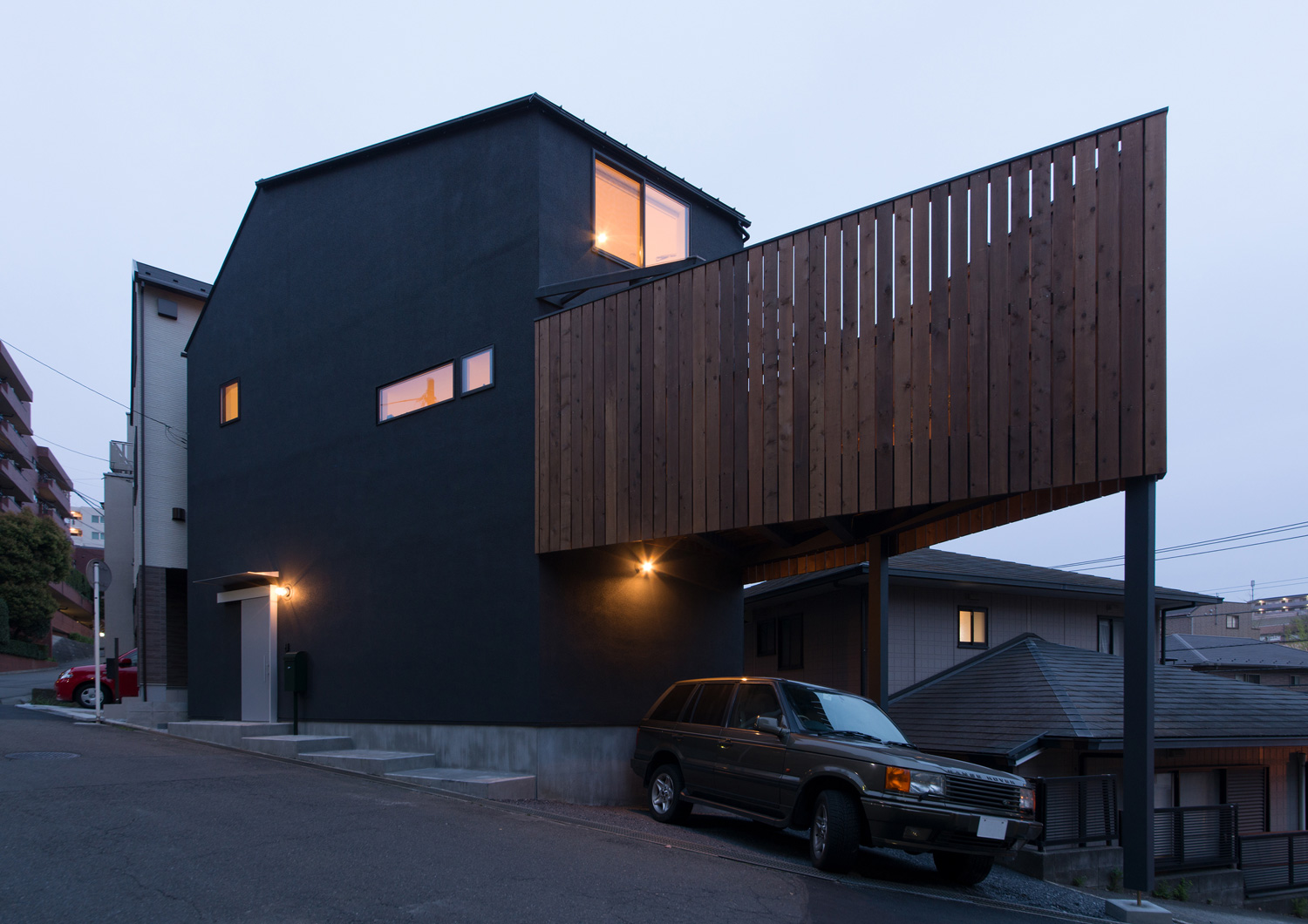 窓から光が漏れるバルコニー付きの住宅を斜めから見た様子・デザイン住宅 注文住宅・デザイン住宅建築実例_『CASE626 Triangle』_外観