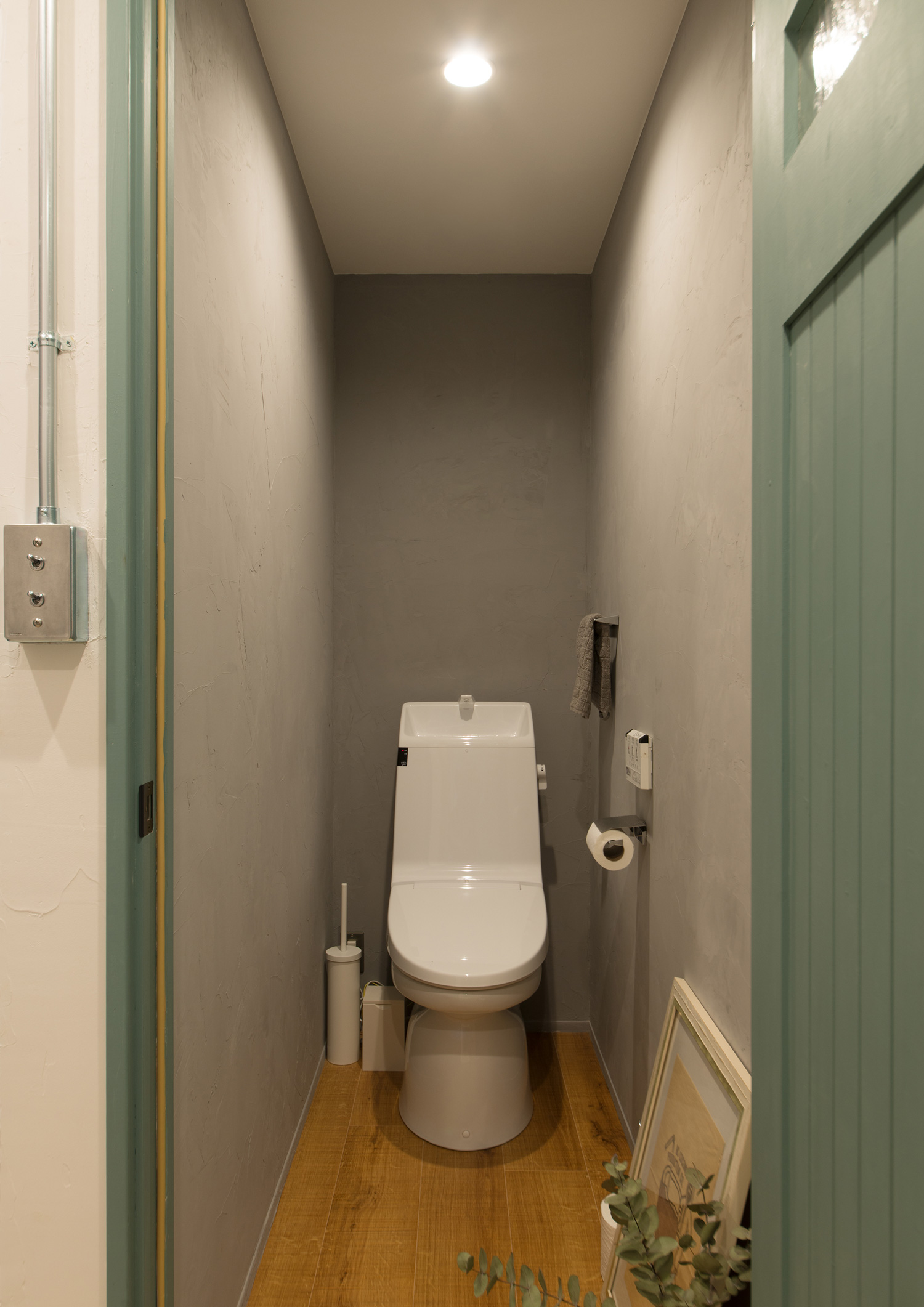 緑色の扉が付いたグレーの壁のトイレ・デザイン住宅 注文住宅・デザイン住宅建築実例_『CASE626 Triangle』_トイレ