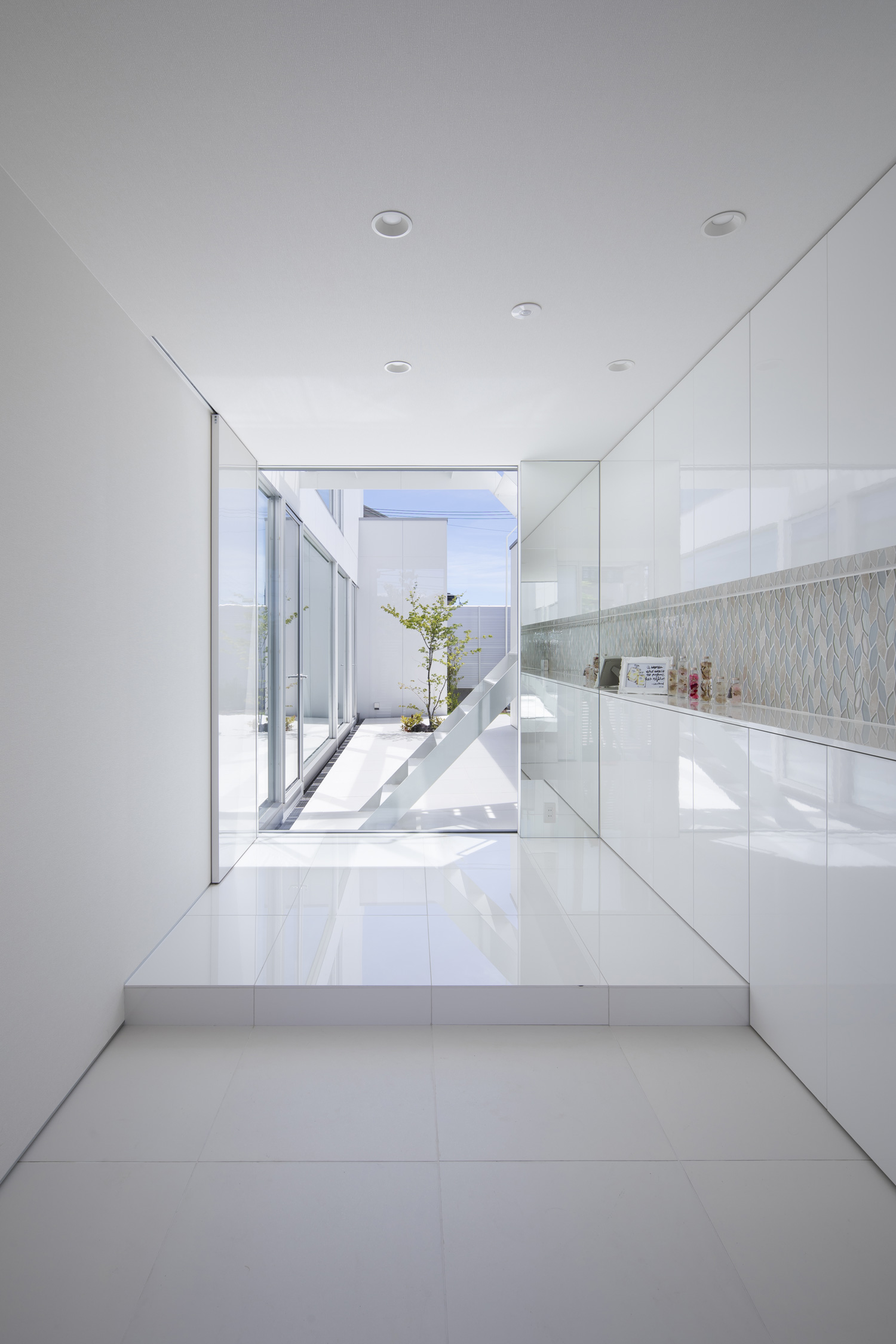 正面に中庭が見える、白で統一された玄関・デザイン住宅 注文住宅・デザイン住宅建築実例_『CASE627 HOUSE . GARAGE HOUSE』_玄関