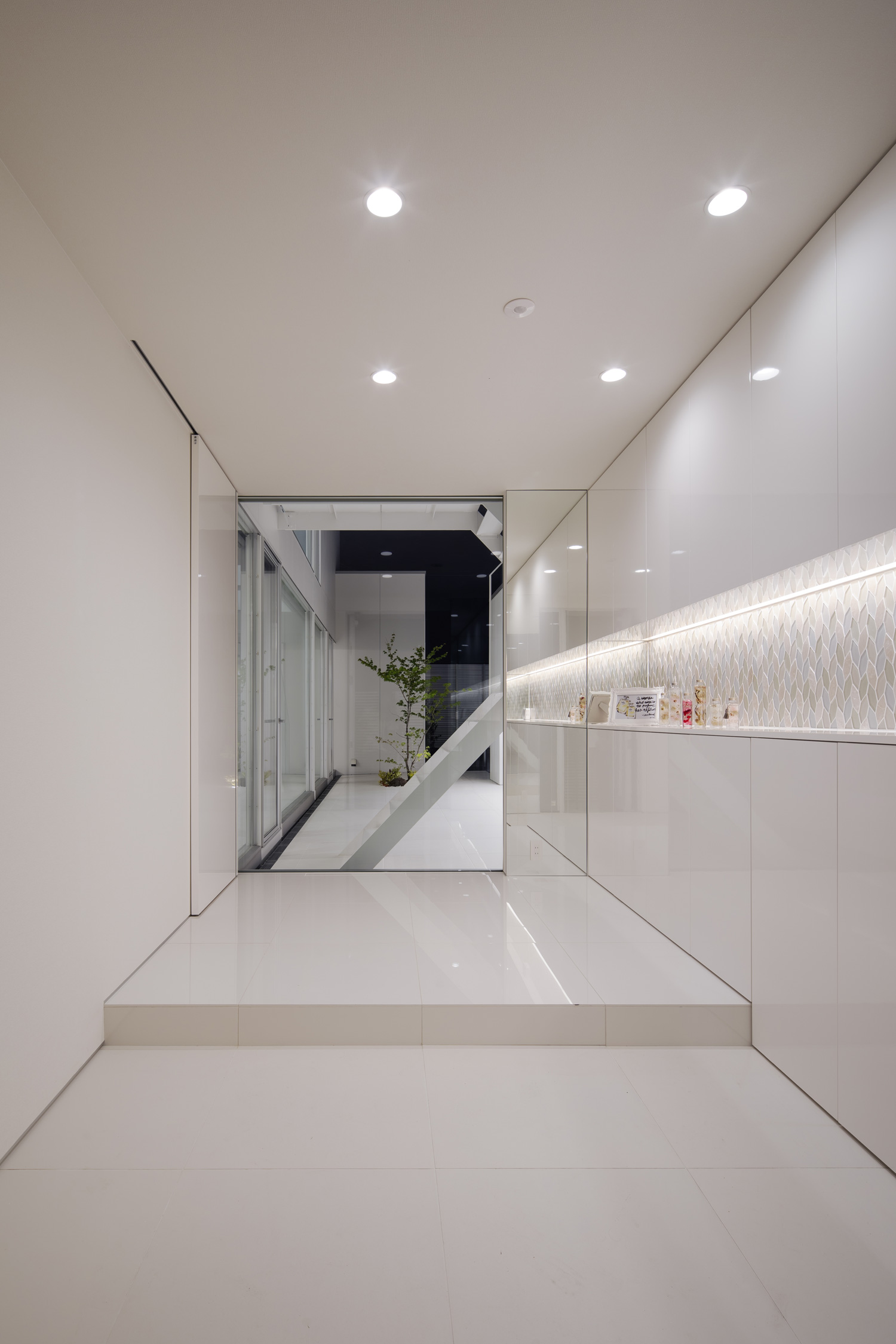 ニッチ壁に間接照明を取り付けた、正面に窓がある白で統一された玄関・デザイン住宅 注文住宅・デザイン住宅建築実例_『CASE627 HOUSE . GARAGE HOUSE』_玄関