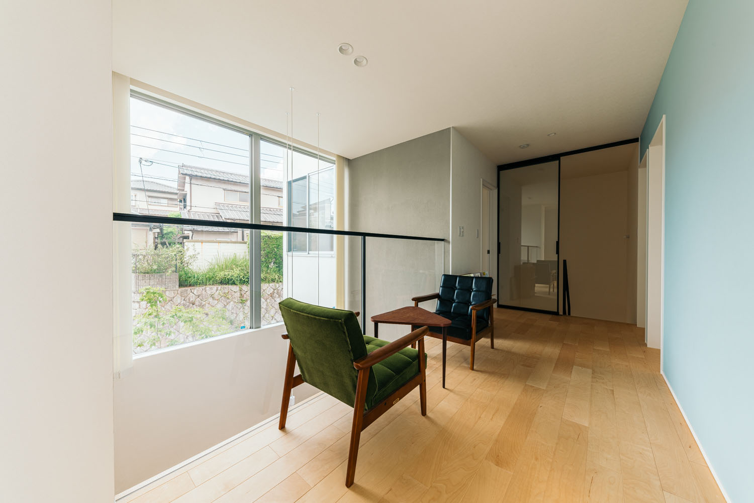 水色のアクセントクロスがありテーブルと椅子が置かれた吹き抜けに面した空間・ホビールームのある家 注文住宅・デザイン住宅建築実例_『CASE684 ホビールームのある家』_フリースペース