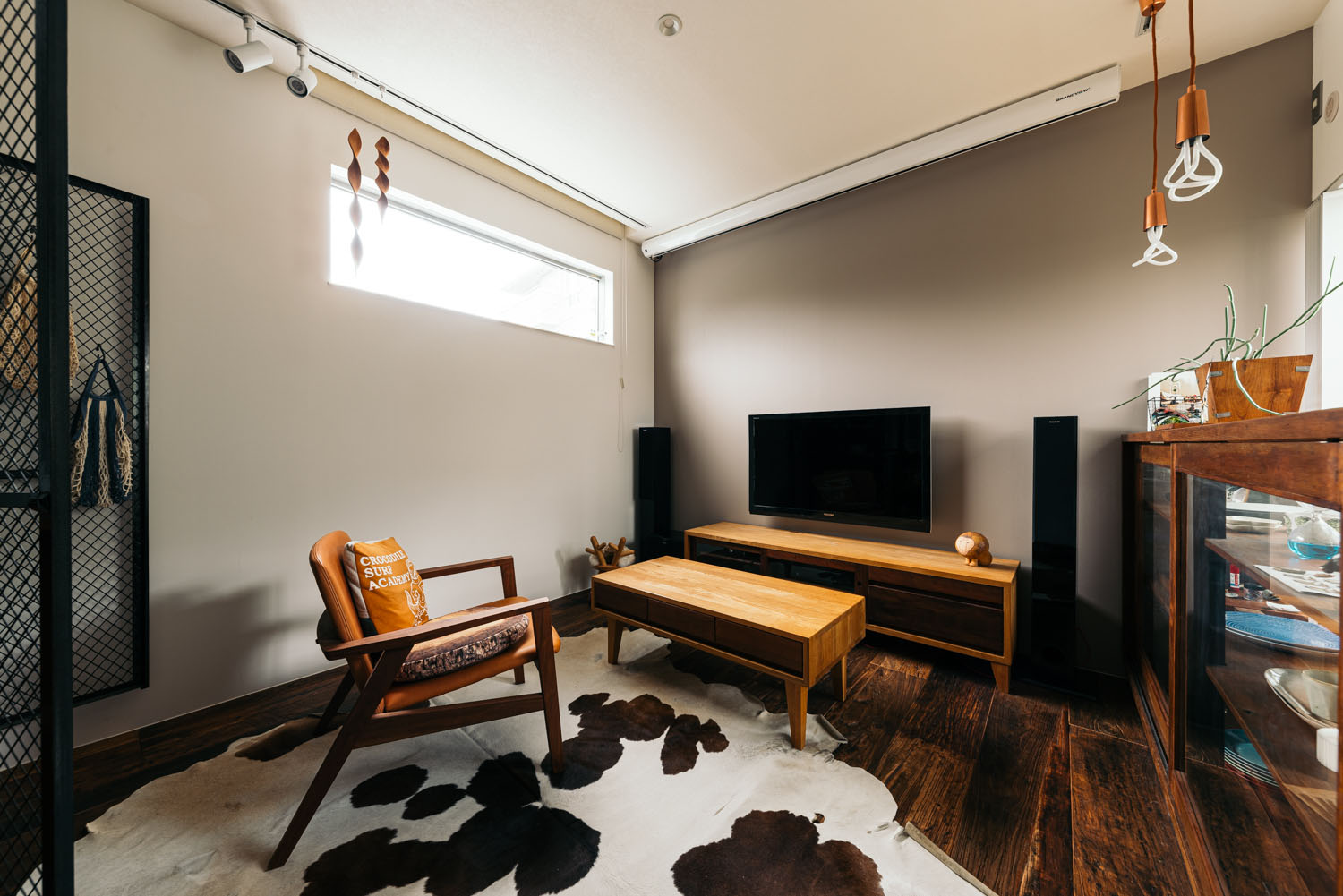 濃い色のフローリングの上にラグがありスリット窓が設けられた部屋・ホビールームのある家 注文住宅・デザイン住宅建築実例_『CASE684 ホビールームのある家』_ホビールーム