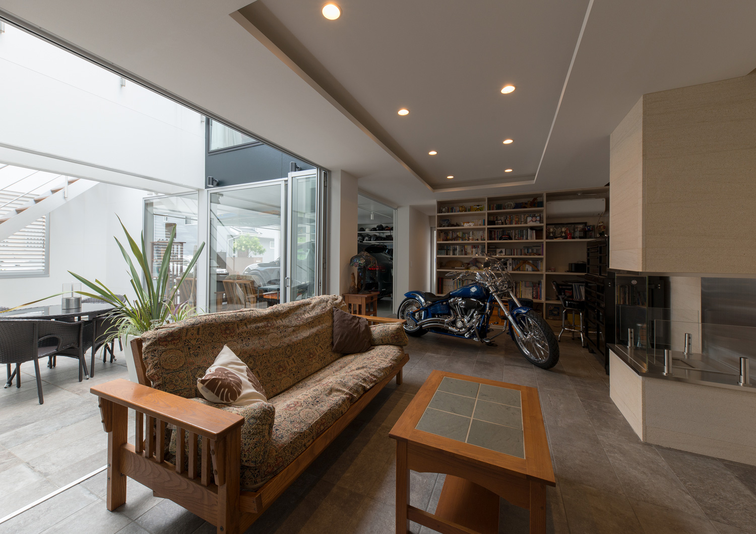 ソファーやテーブルの他にバイクが置かれた中庭に面した部屋・デザイン住宅 注文住宅・デザイン住宅建築実例_『CASE593 CAMP』_中庭