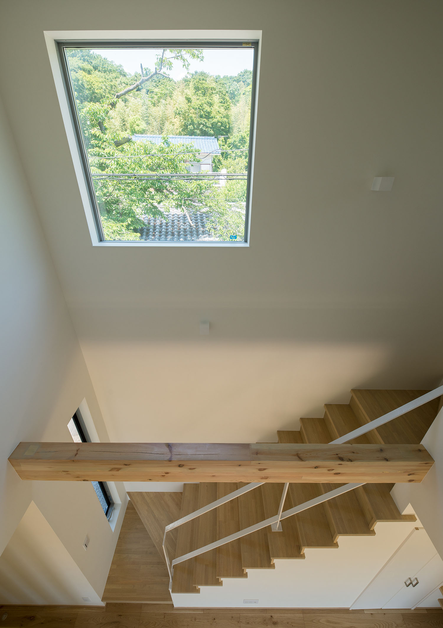 緑が見える窓を設けた白と木材のナチュラルな階段室・デザイン住宅 注文住宅・デザイン住宅建築実例_『CASE550 three box house』_階段
