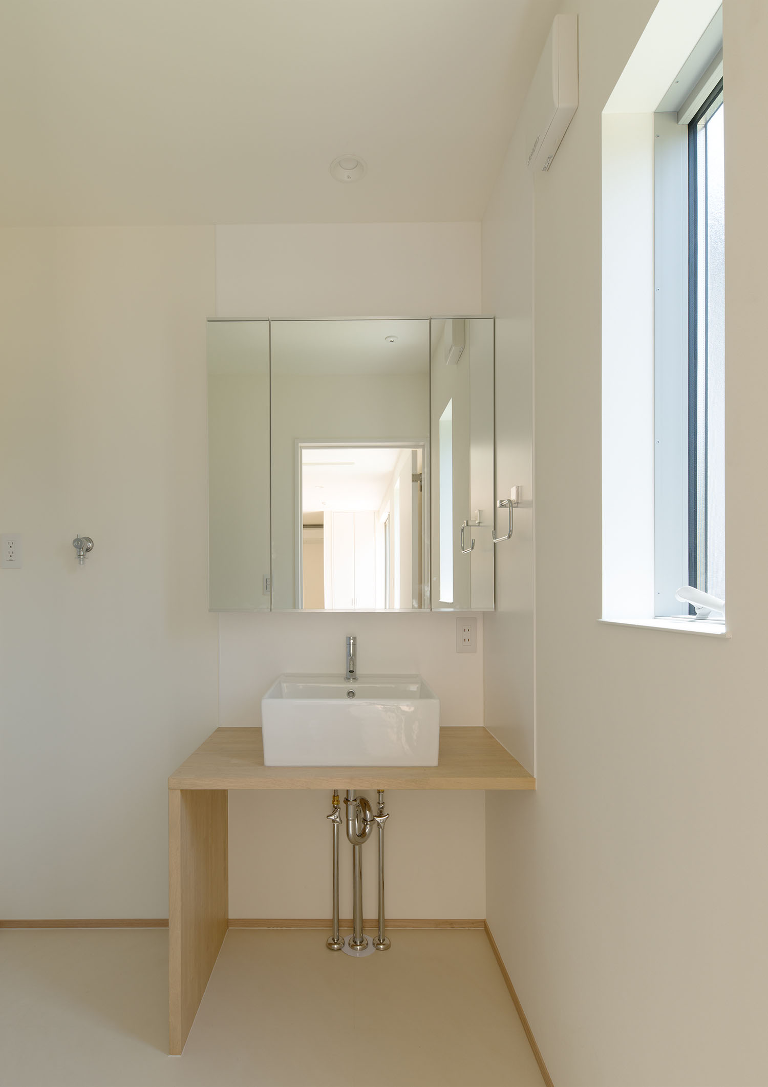 木の洗面台にシンプルな洗面ボウルを取り付けたミニマルな洗面所・デザイン住宅 注文住宅・デザイン住宅建築実例_『CASE550 three box house』_浴室・洗面所