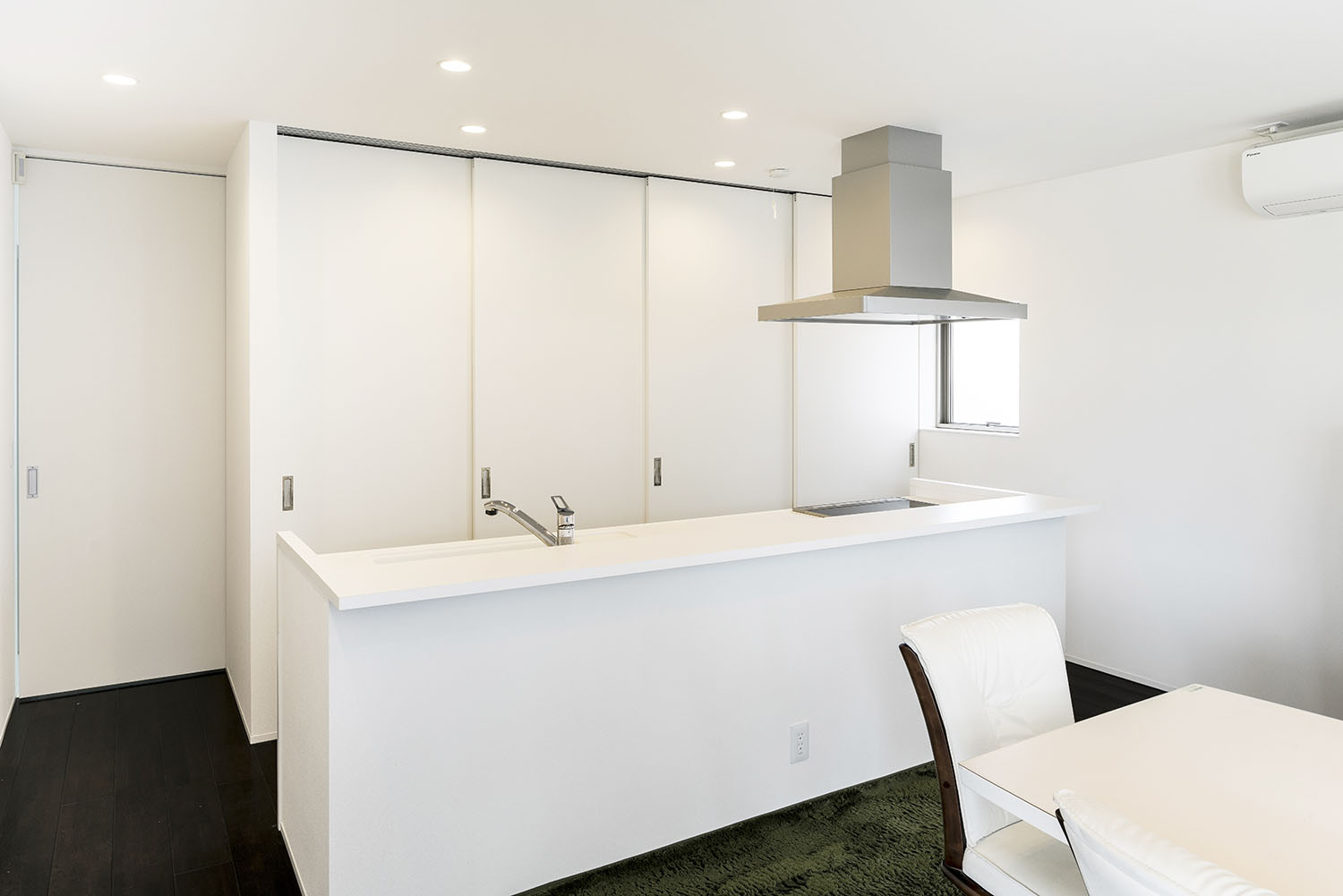 扉付きのカップボードがある白いアイランドキッチン・デザイン住宅 注文住宅・デザイン住宅建築実例_『CASE581 Tcourt』_キッチン