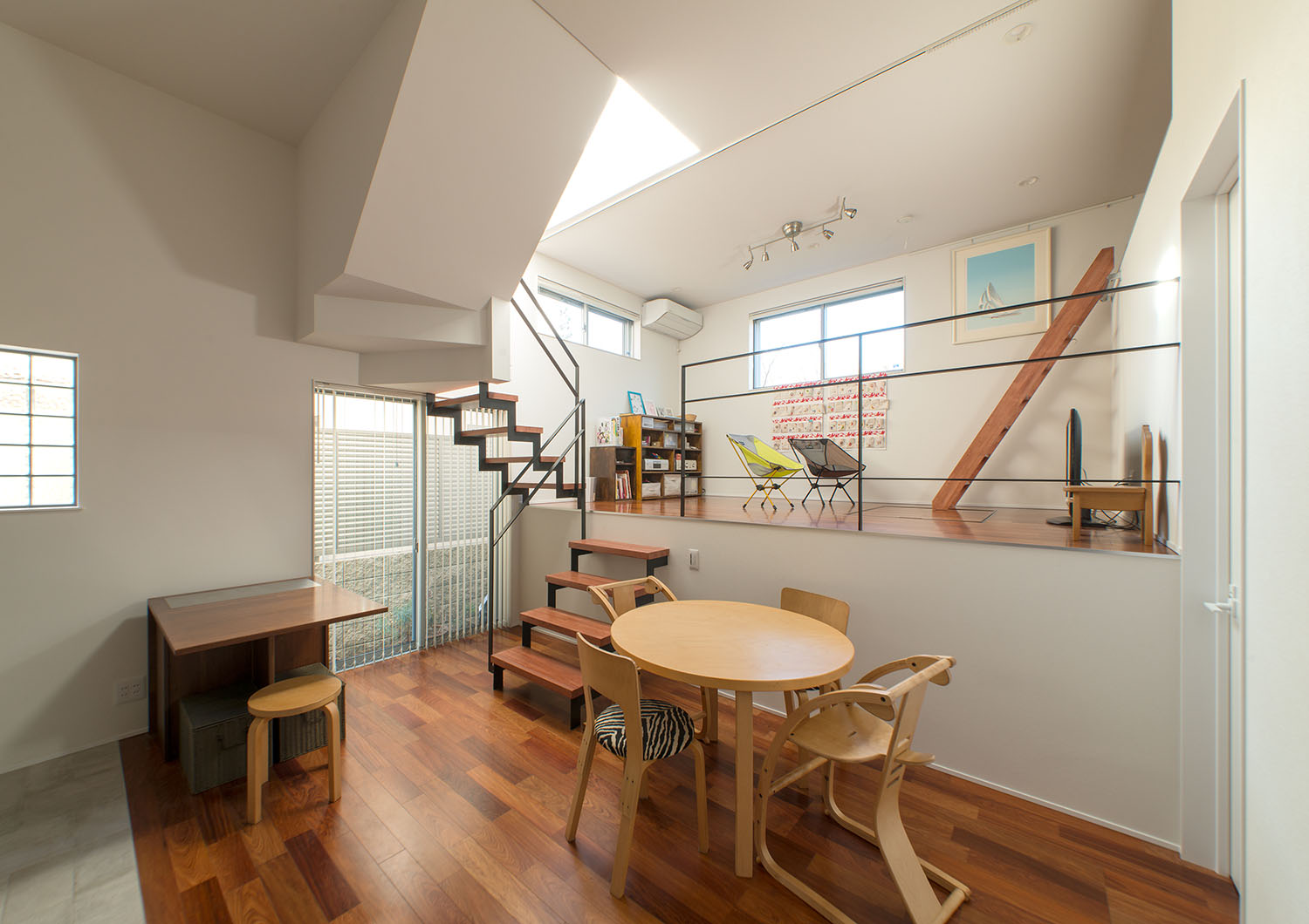 木の丸テーブルが置かれたスキップフロアのあるLDK・デザイン住宅 注文住宅・デザイン住宅建築実例_『CASE625 ヒカリの家』_LDK