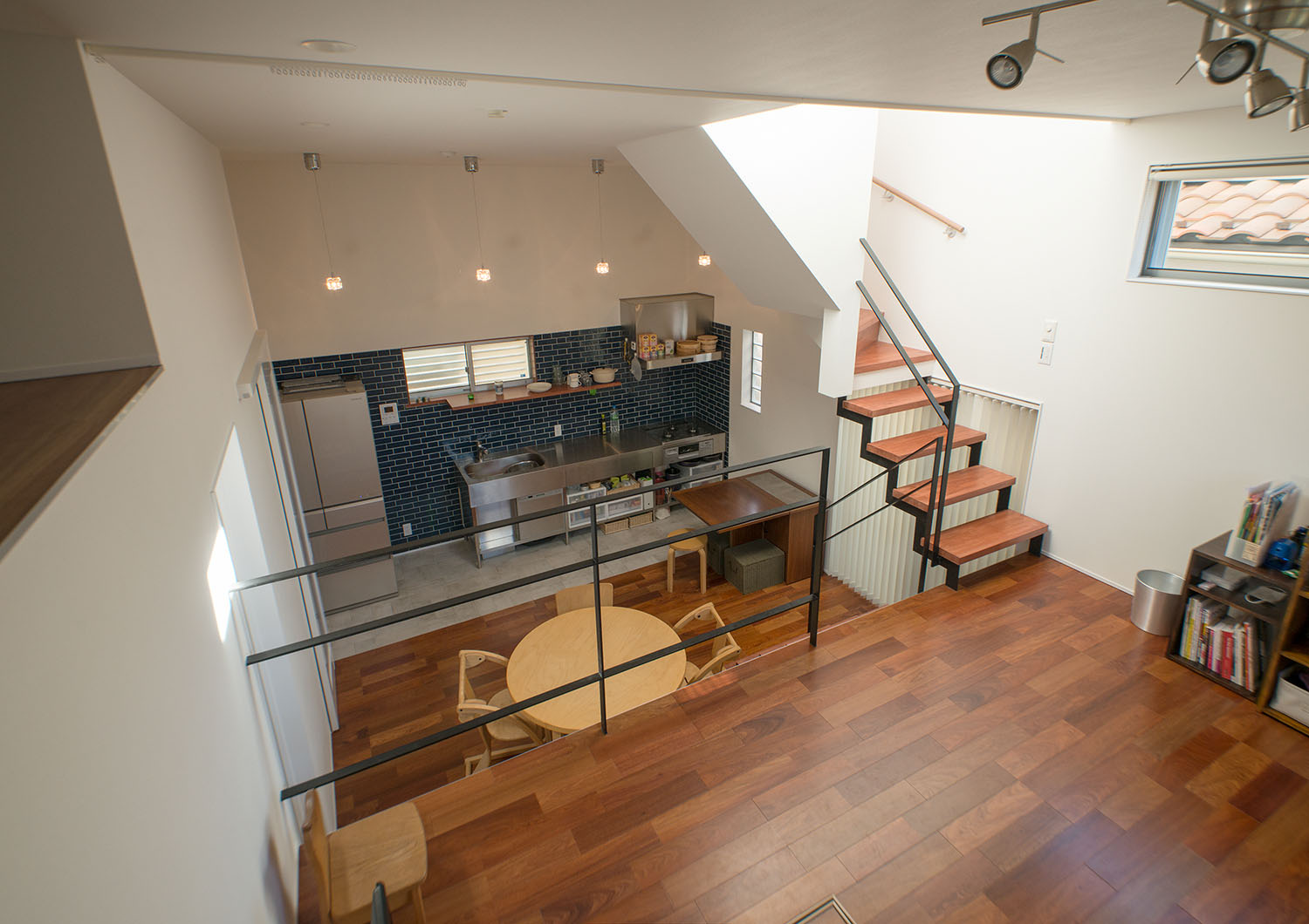 木の丸テーブルがある一階のダイニングとフローリングの色が統一されたスキップフロア・デザイン住宅 注文住宅・デザイン住宅建築実例_『CASE625 ヒカリの家』_LDK