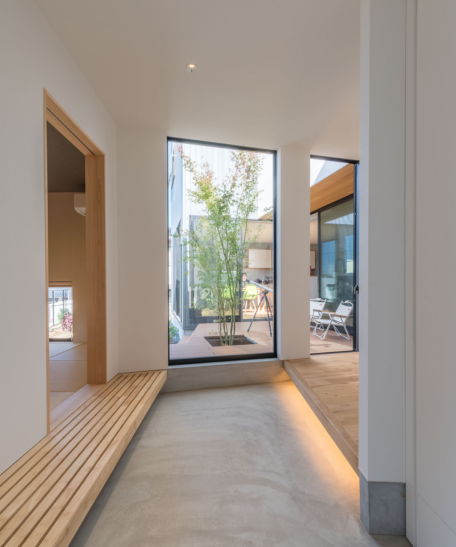 正面に植栽が見える窓がある開放的なモルタル玄関・デザイン住宅 注文住宅・デザイン住宅建築実例_『CASE505 silhouette』_玄関