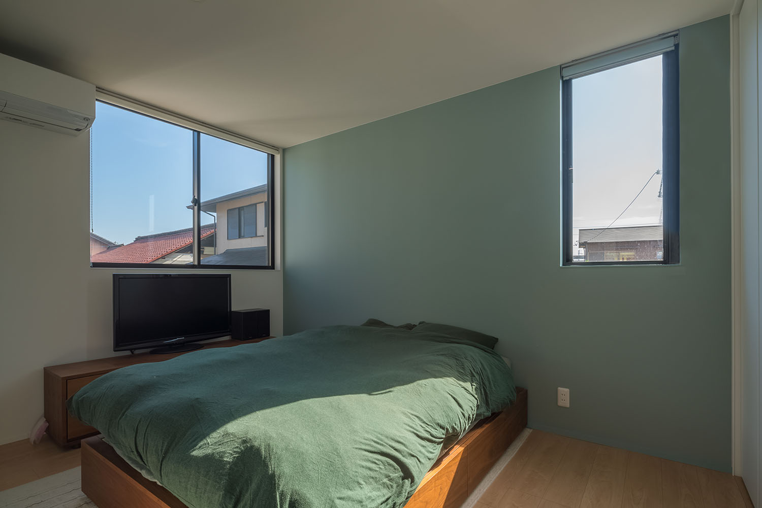 グリーンのシーツのベッドにグリーンのアクセントクロスがある寝室・デザイン住宅 注文住宅・デザイン住宅建築実例_『CASE505 silhouette』_寝室