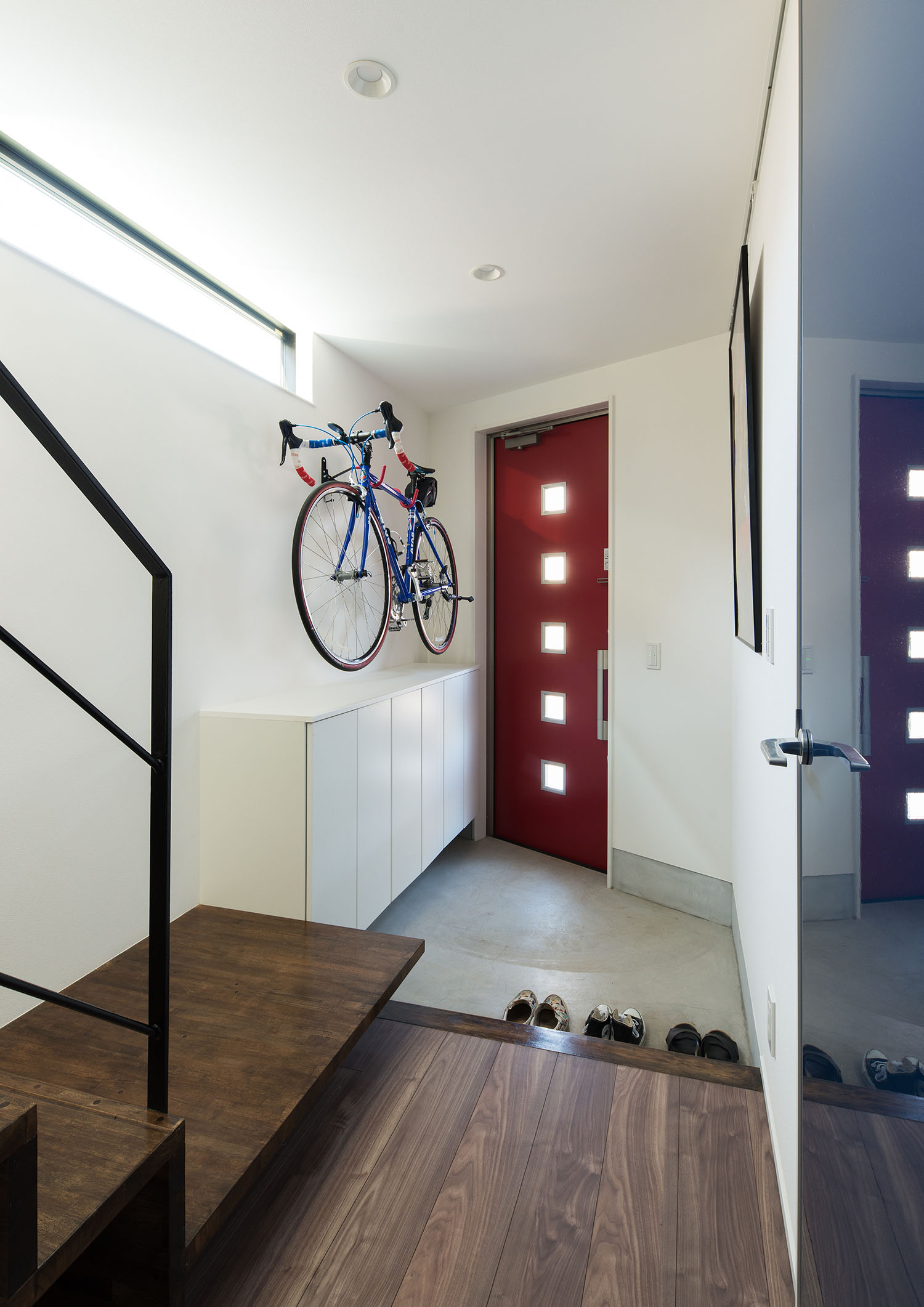 自転車が壁にかけられている赤い玄関扉の玄関・デザイン住宅 注文住宅・デザイン住宅建築実例_『CASE594 TOOL BOX』_玄関