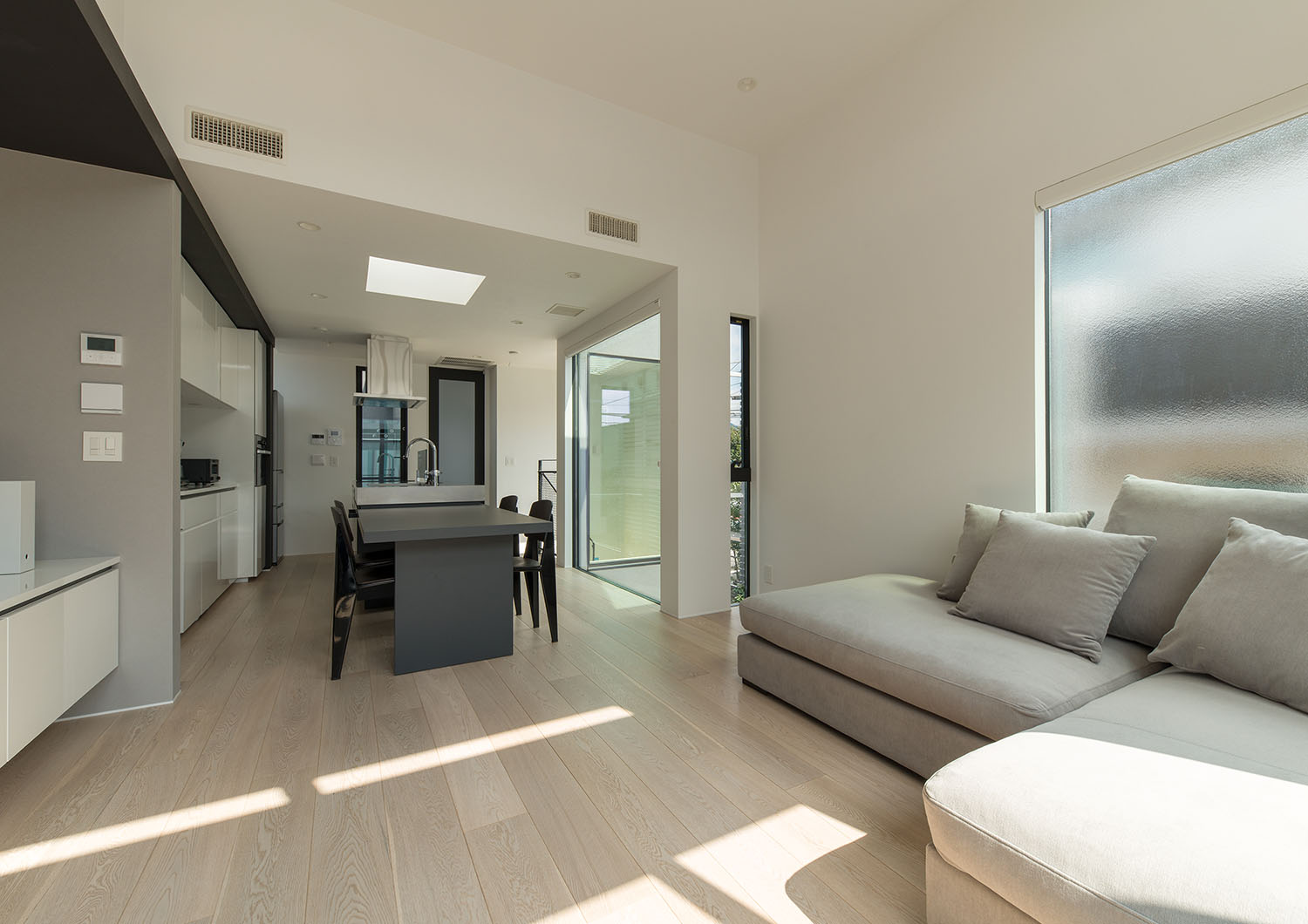 中庭に面した窓や曇りガラスの窓があるL字ソファーを置いたLDK・デザイン住宅 注文住宅・デザイン住宅建築実例_『CASE597 Ambiguous Expression』_LDK