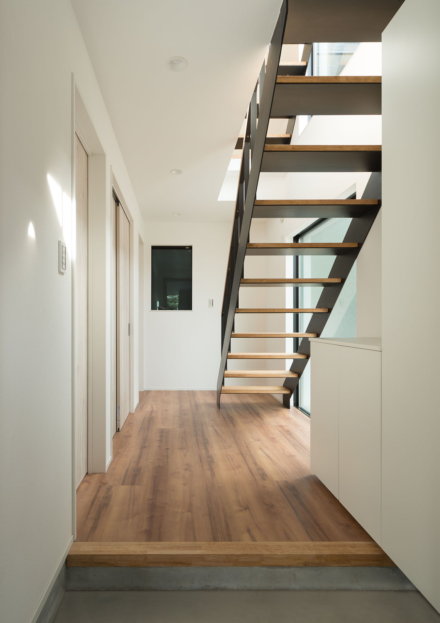 木のスケルトン階段が正面に見える玄関・デザイン住宅 注文住宅・デザイン住宅建築実例_『CASE599 日向ぼっこしたくなる階段のある家』_玄関