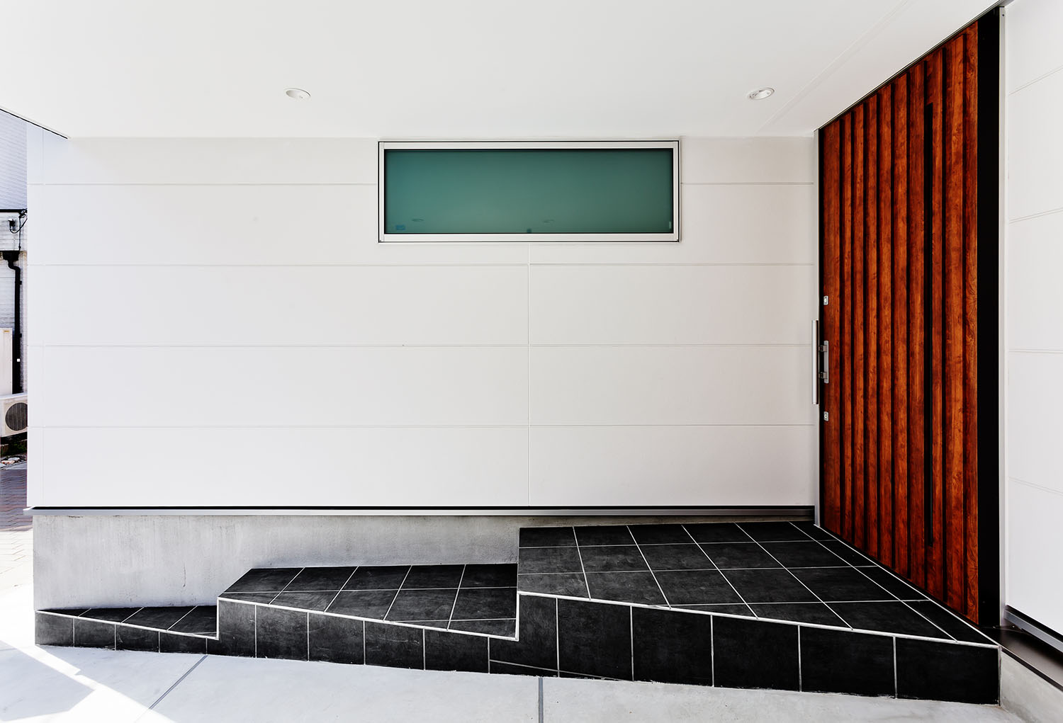 黒いタイルのアプローチや木の玄関扉があるエントランス・デザイン住宅 注文住宅・デザイン住宅建築実例_『CASE618 陽が射す家』_外観