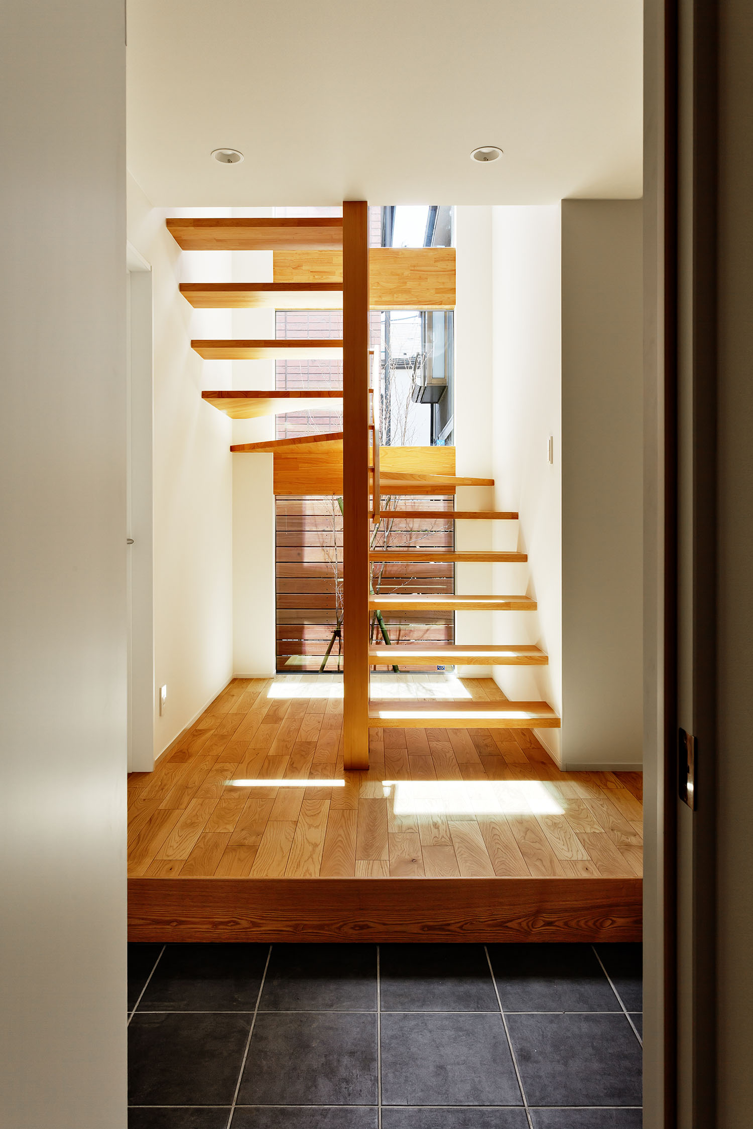 窓の前にある木製のスケルトン階段・デザイン住宅 注文住宅・デザイン住宅建築実例_『CASE618 陽が射す家』_玄関