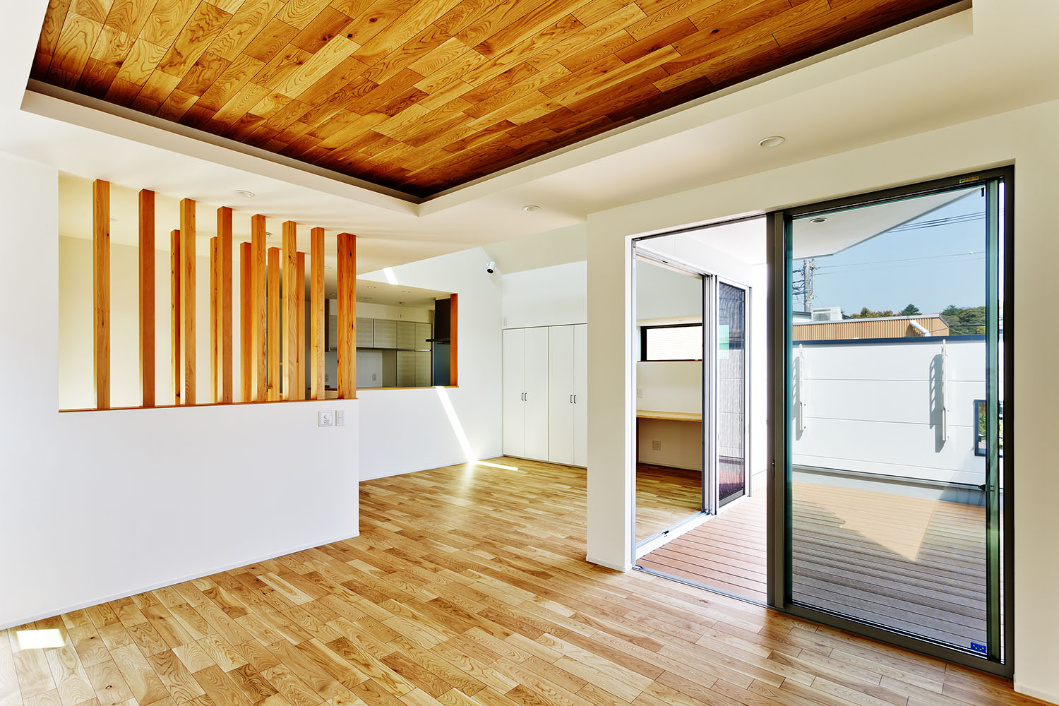 ウッドデッキのバルコニーとフラットに繋がる木目の天井のLDK・デザイン住宅 注文住宅・デザイン住宅建築実例_『CASE618 陽が射す家』_LDK