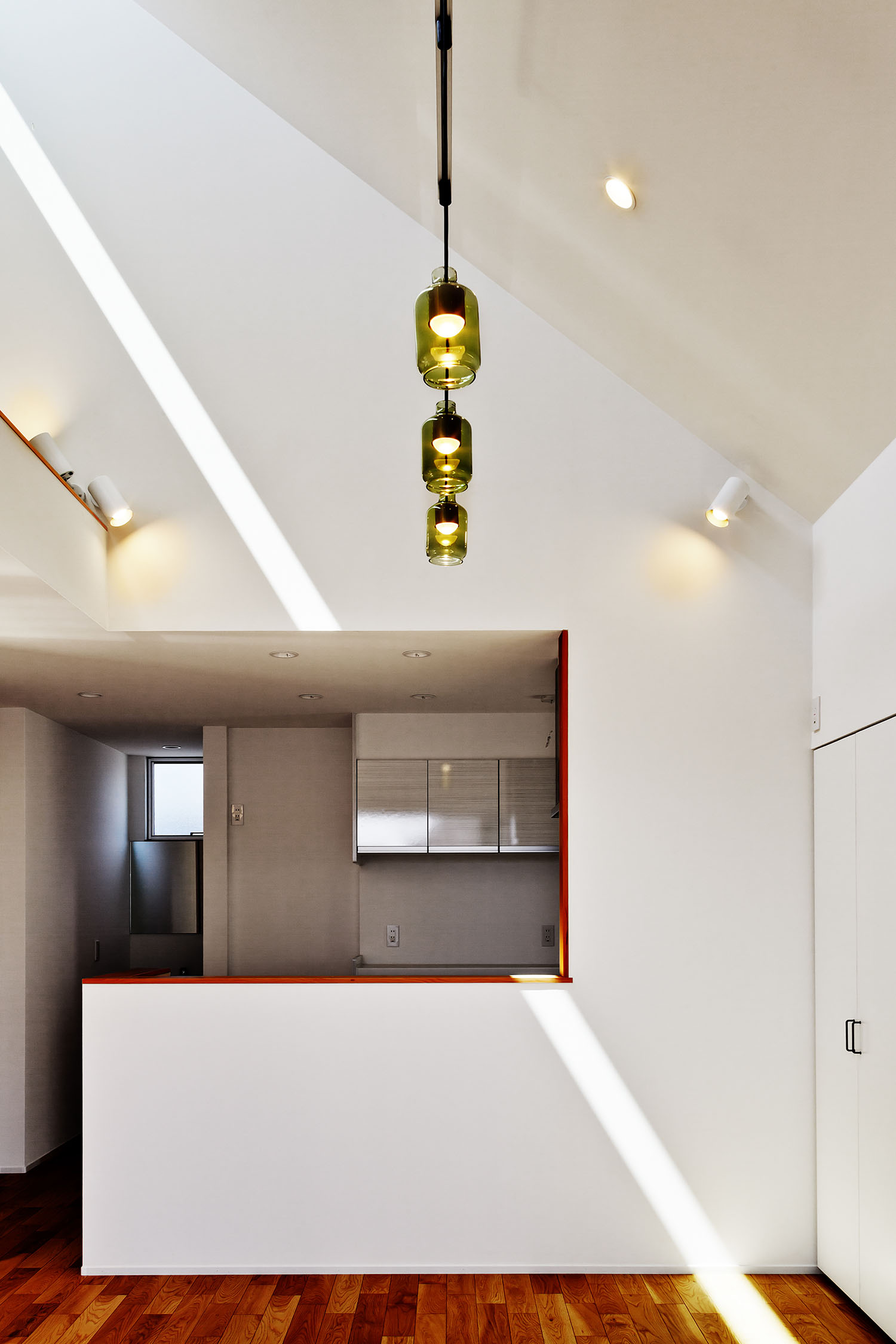 壁付けのスポットライトや、ペンダントライトが取り付けられた高天井のLDK・デザイン住宅 注文住宅・デザイン住宅建築実例_『CASE618 陽が射す家』_LDK