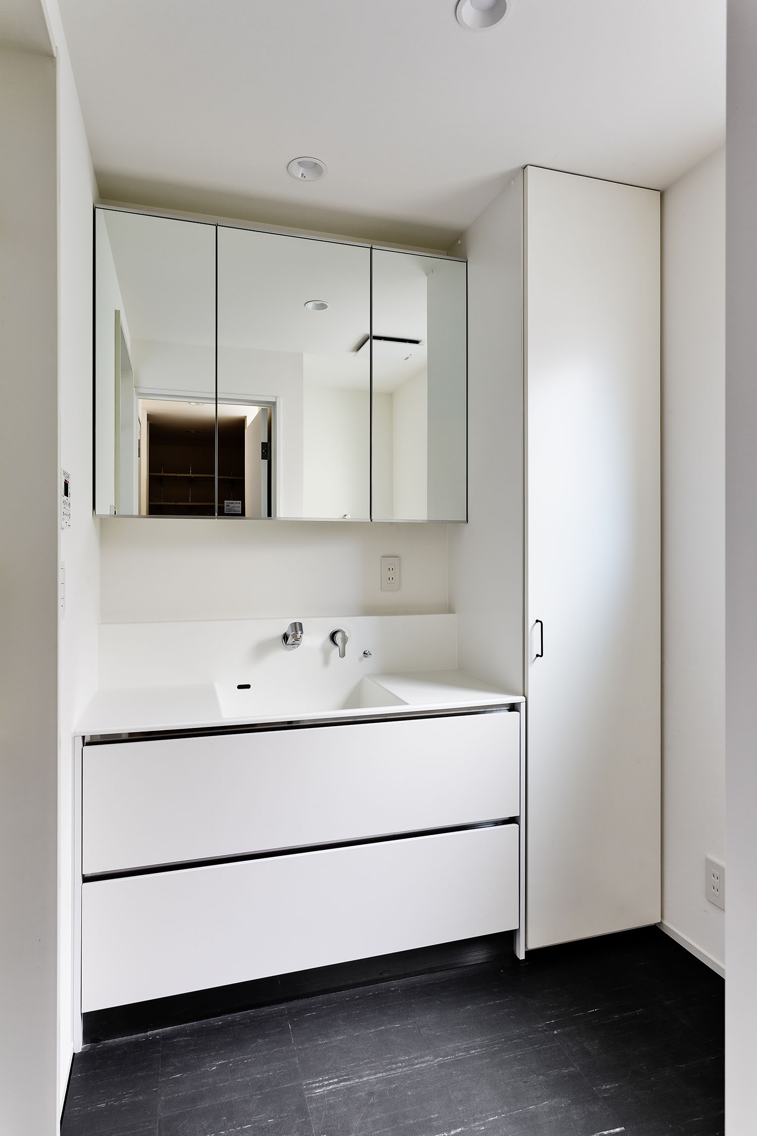 黒い床で、扉付きの収納がある洗面所・デザイン住宅 注文住宅・デザイン住宅建築実例_『CASE618 陽が射す家』_浴室・洗面所