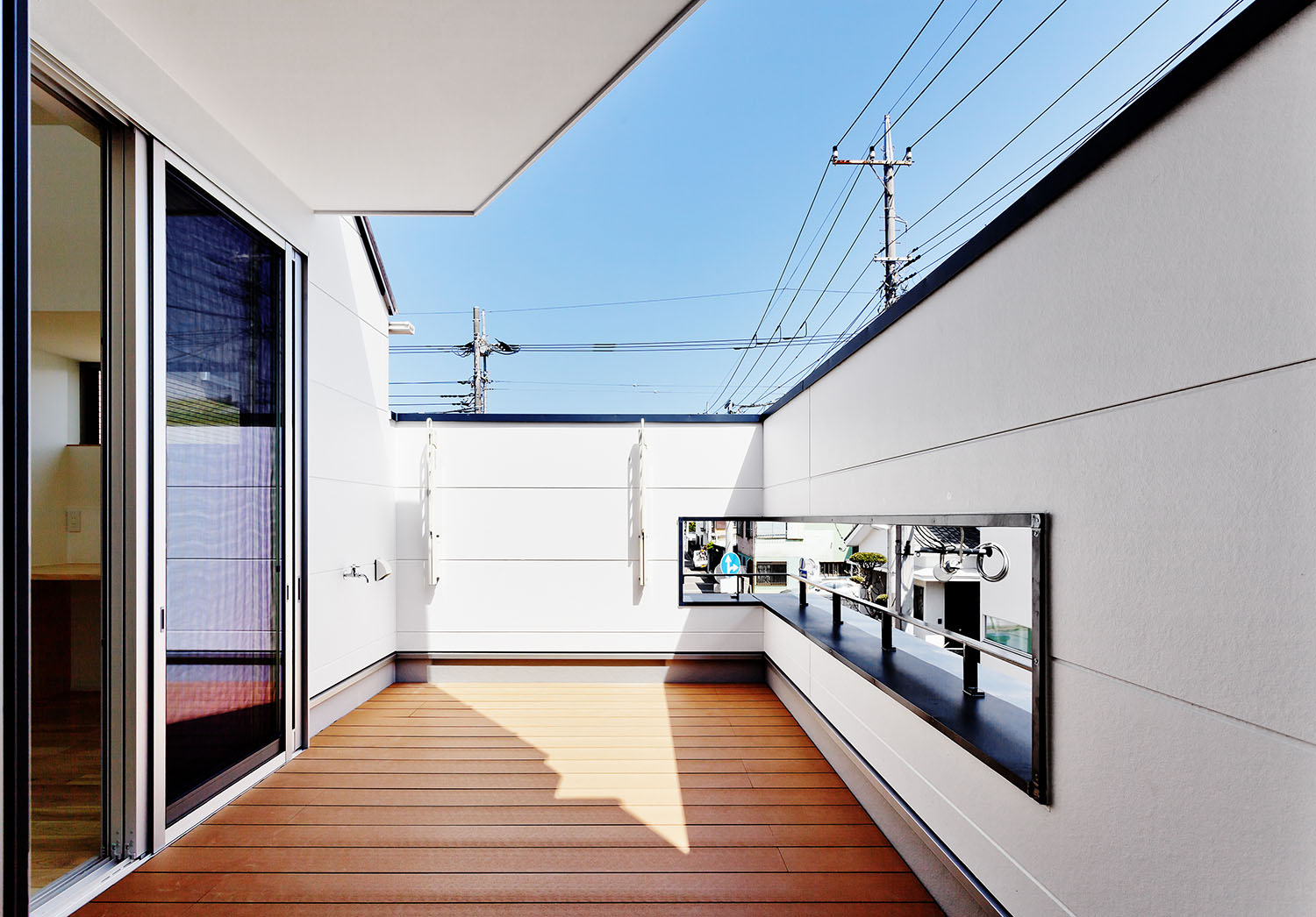 高い目隠し壁の中央にスリットを設けたウッドデッキのバルコニー・デザイン住宅 注文住宅・デザイン住宅建築実例_『CASE618 陽が射す家』_テラス・バルコニー