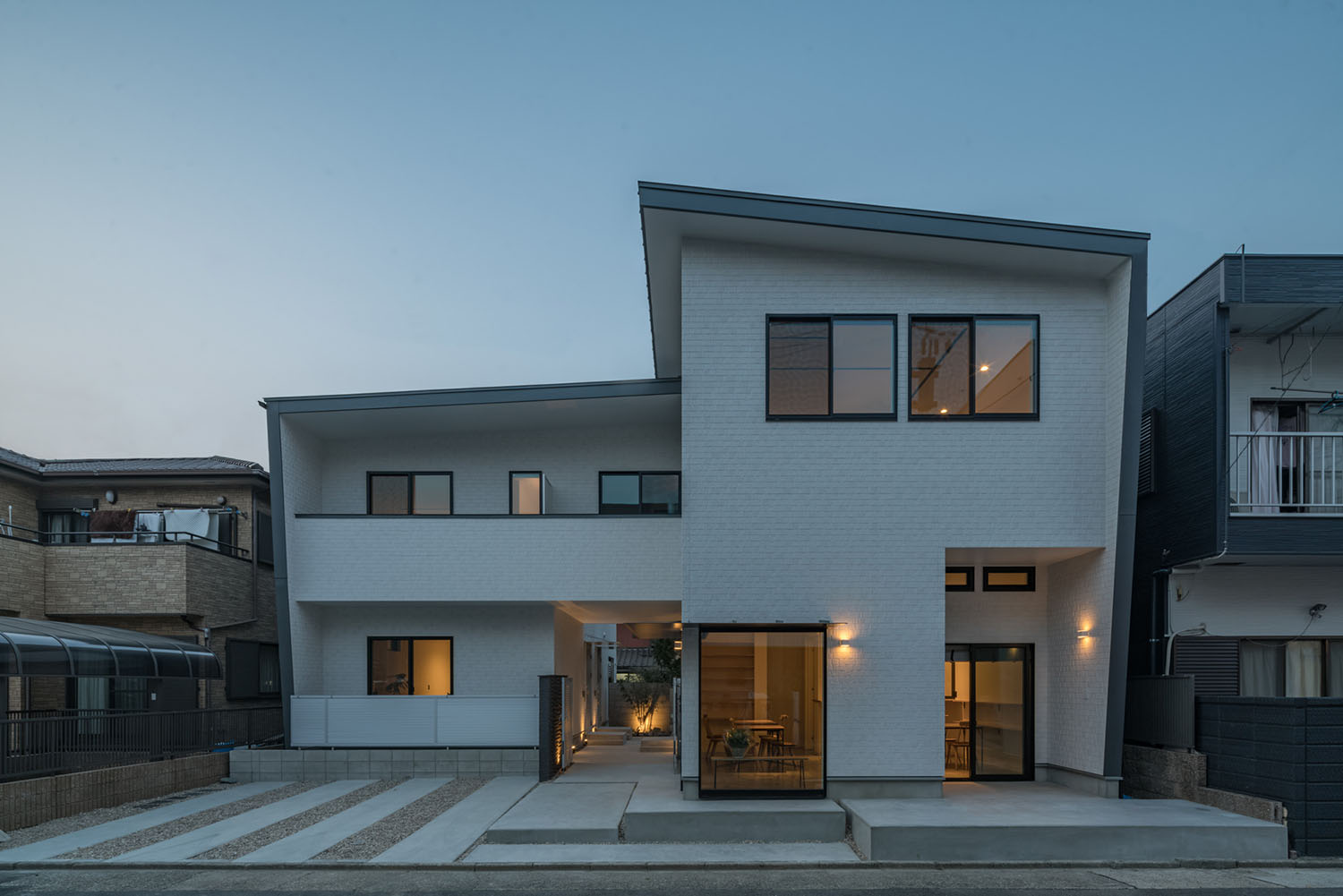 壁に間接照明が取り付けられた白い外壁のアパートメント・デザイン住宅 注文住宅・デザイン住宅建築実例_『CASE623 HOUSest-Life+Cafe』_外観