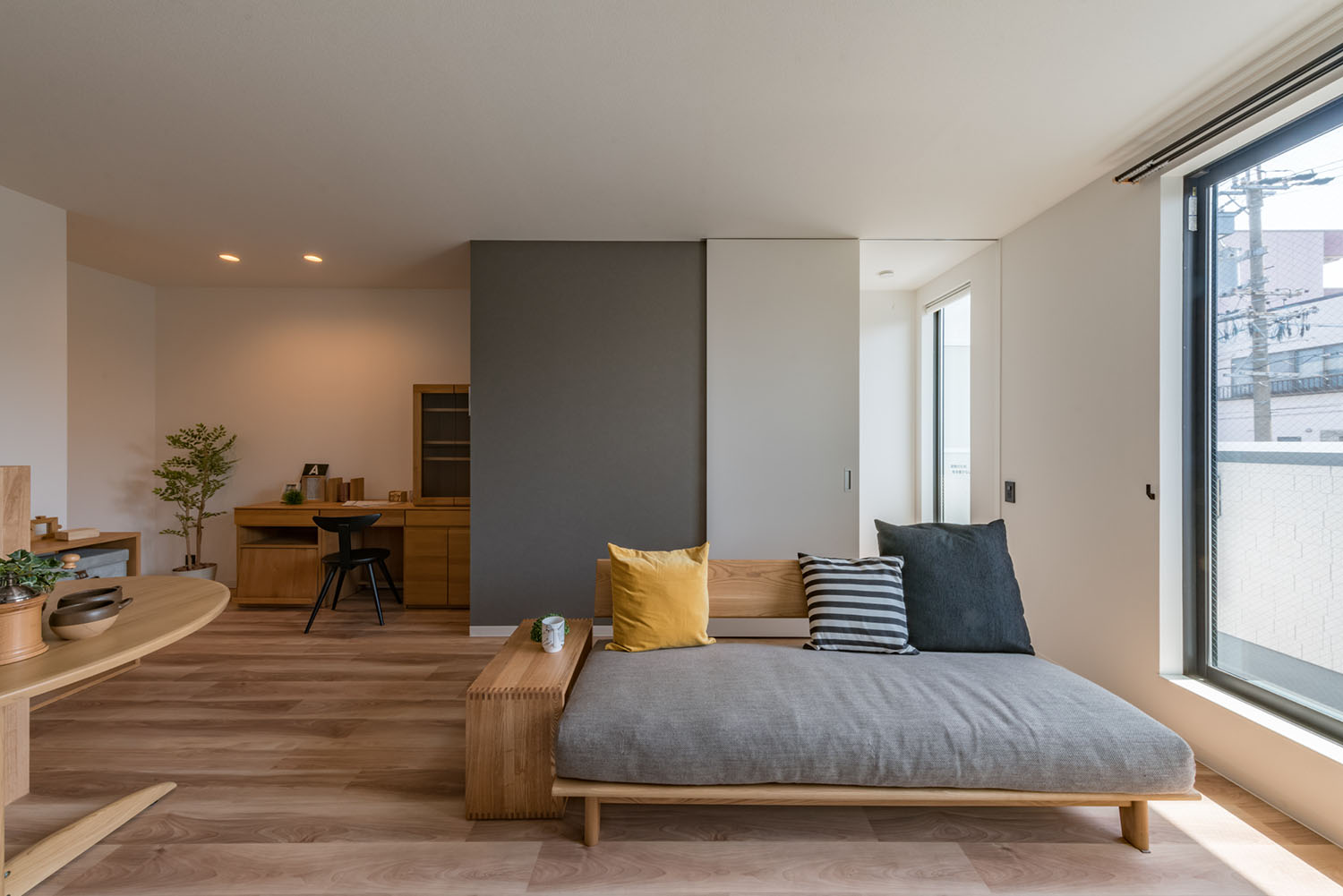 グレーのソファーが置かれた、木の壁付けデスクがあるLDK・デザイン住宅 注文住宅・デザイン住宅建築実例_『CASE623 HOUSest-Life+Cafe』_LDK