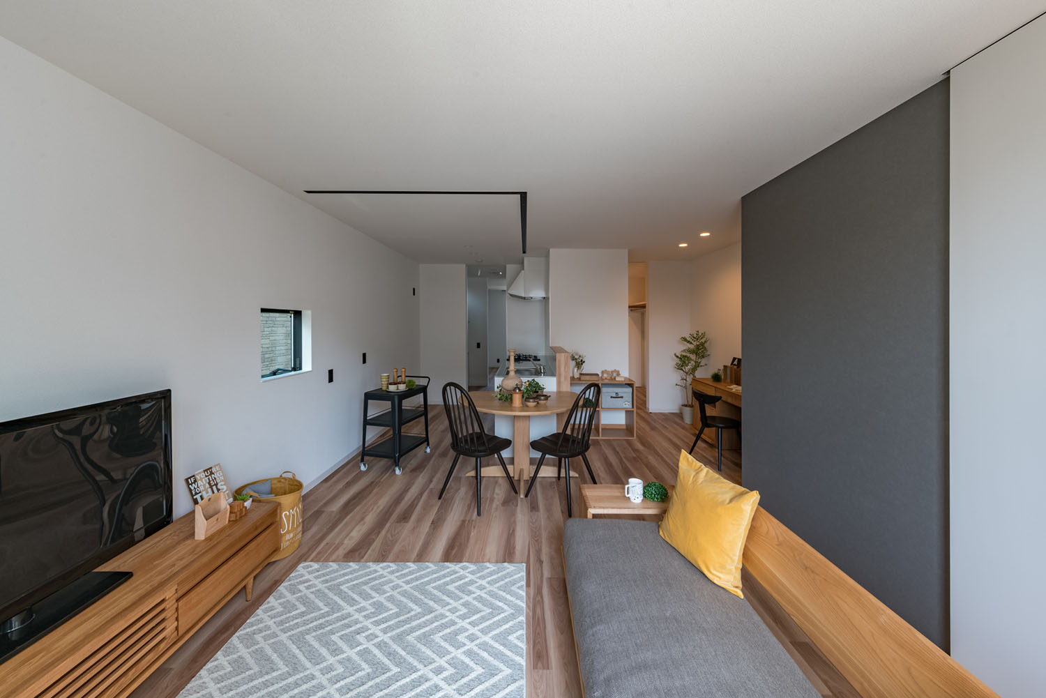 グレーのソファーや木の丸テーブルが置かれたLDK・デザイン住宅 注文住宅・デザイン住宅建築実例_『CASE623 HOUSest-Life+Cafe』_LDK