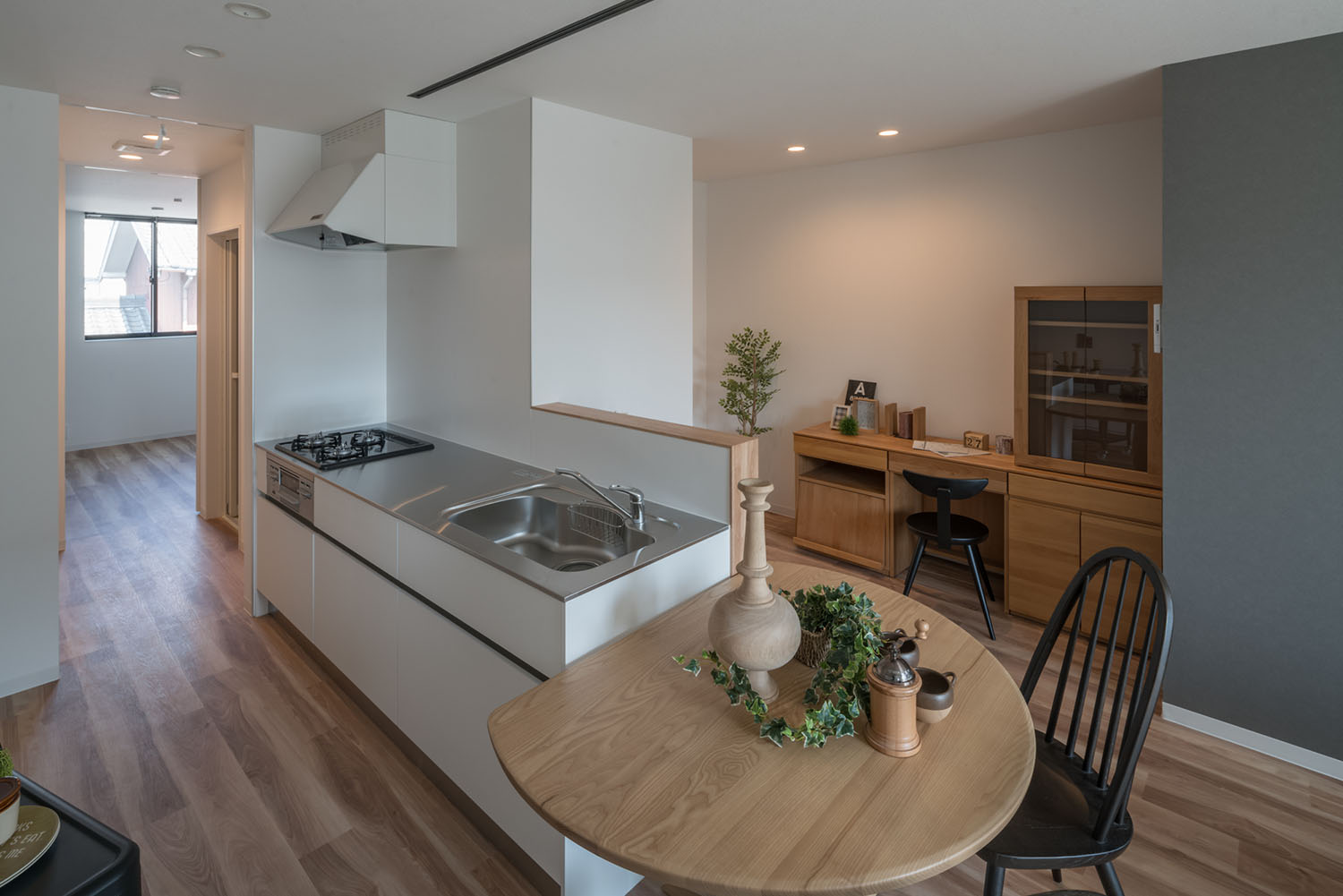 キッチンの隣に丸い木製のテーブルが置かれたLDK・デザイン住宅 注文住宅・デザイン住宅建築実例_『CASE623 HOUSest-Life+Cafe』_キッチン