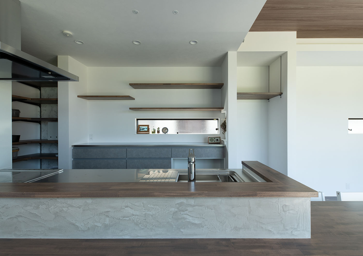 白い壁に、木の壁付けの棚を設けたキッチン・デザイン住宅 注文住宅・デザイン住宅建築実例_『CASE685 flat scale』_キッチン