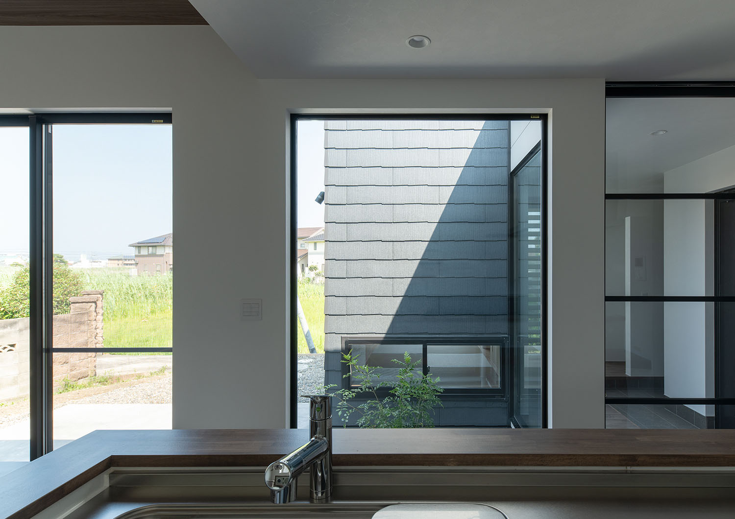 キッチンから窓越しに中庭が見える様子・デザイン住宅 注文住宅・デザイン住宅建築実例_『CASE685 flat scale』_キッチン