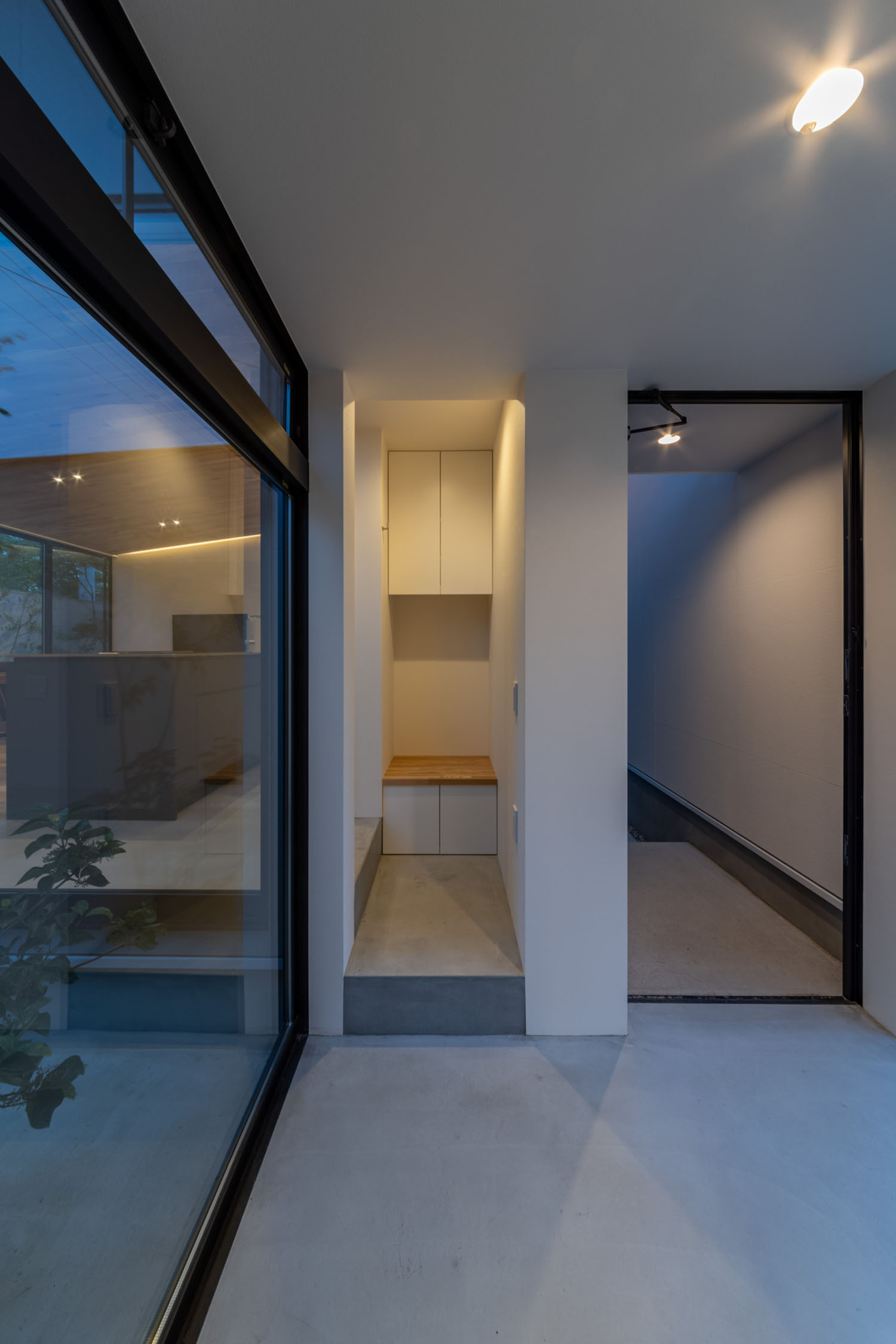 中庭の見える土間空間の先に、飾り棚がある様子・デザイン住宅 注文住宅・デザイン住宅建築実例_『CASE686 桜並木の平屋』_玄関