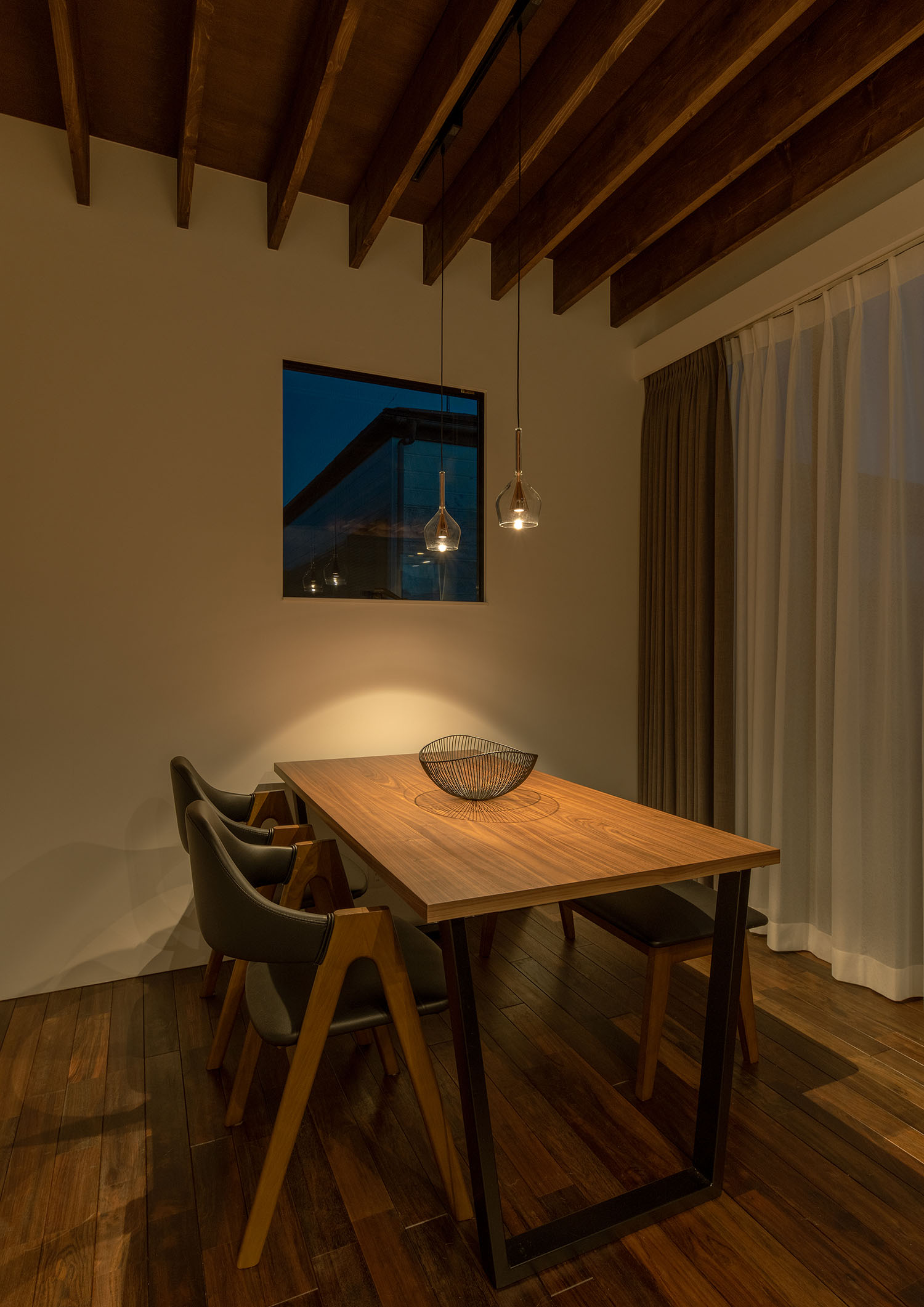 梁見せ天井に取り付けられたペンダントライトに照らされるダイニングテーブル・デザイン住宅 注文住宅・デザイン住宅建築実例_『CASE687 "□×□×和 (ハコニワ)"』_LDK