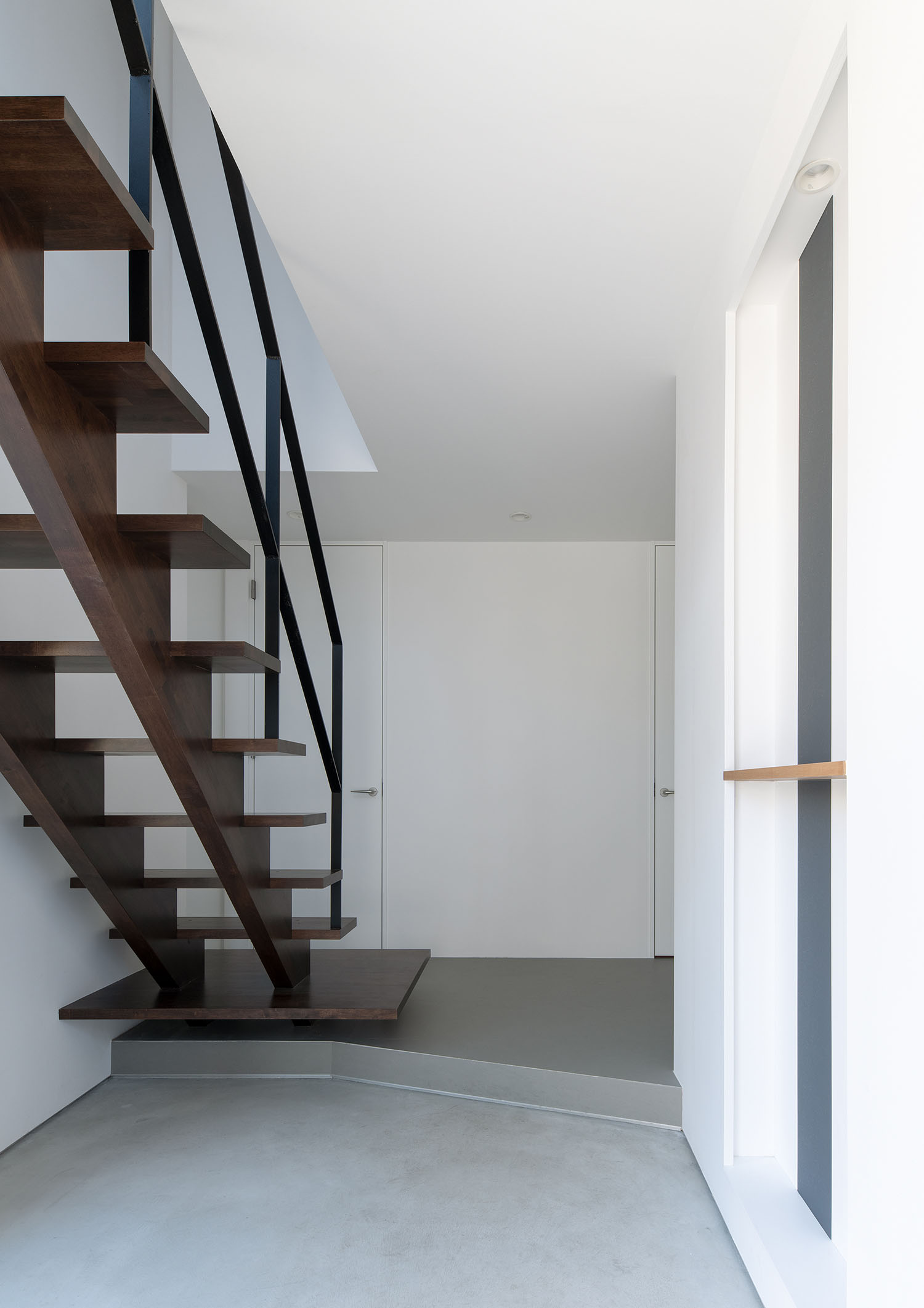 モルタルの玄関のそばにスケルトン階段がある様子・デザイン住宅 注文住宅・デザイン住宅建築実例_『CASE687 "□×□×和 (ハコニワ)"』_玄関