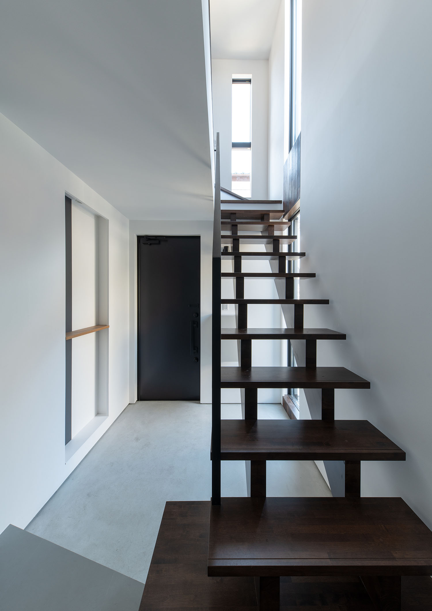 白を基調とした玄関にあるダークブラウンのスケルトン階段・デザイン住宅 注文住宅・デザイン住宅建築実例_『CASE687 "□×□×和 (ハコニワ)"』_階段