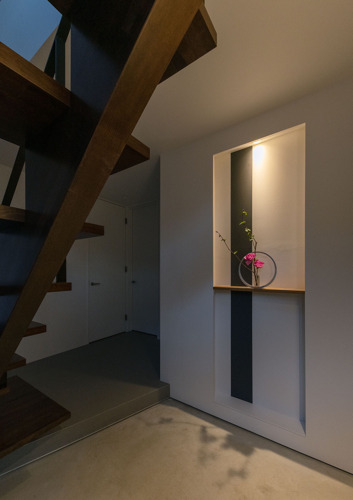 間接照明付きの飾り棚に、生け花が飾られているモルタルの玄関・デザイン住宅 注文住宅・デザイン住宅建築実例_『CASE687 "□×□×和 (ハコニワ)"』_玄関