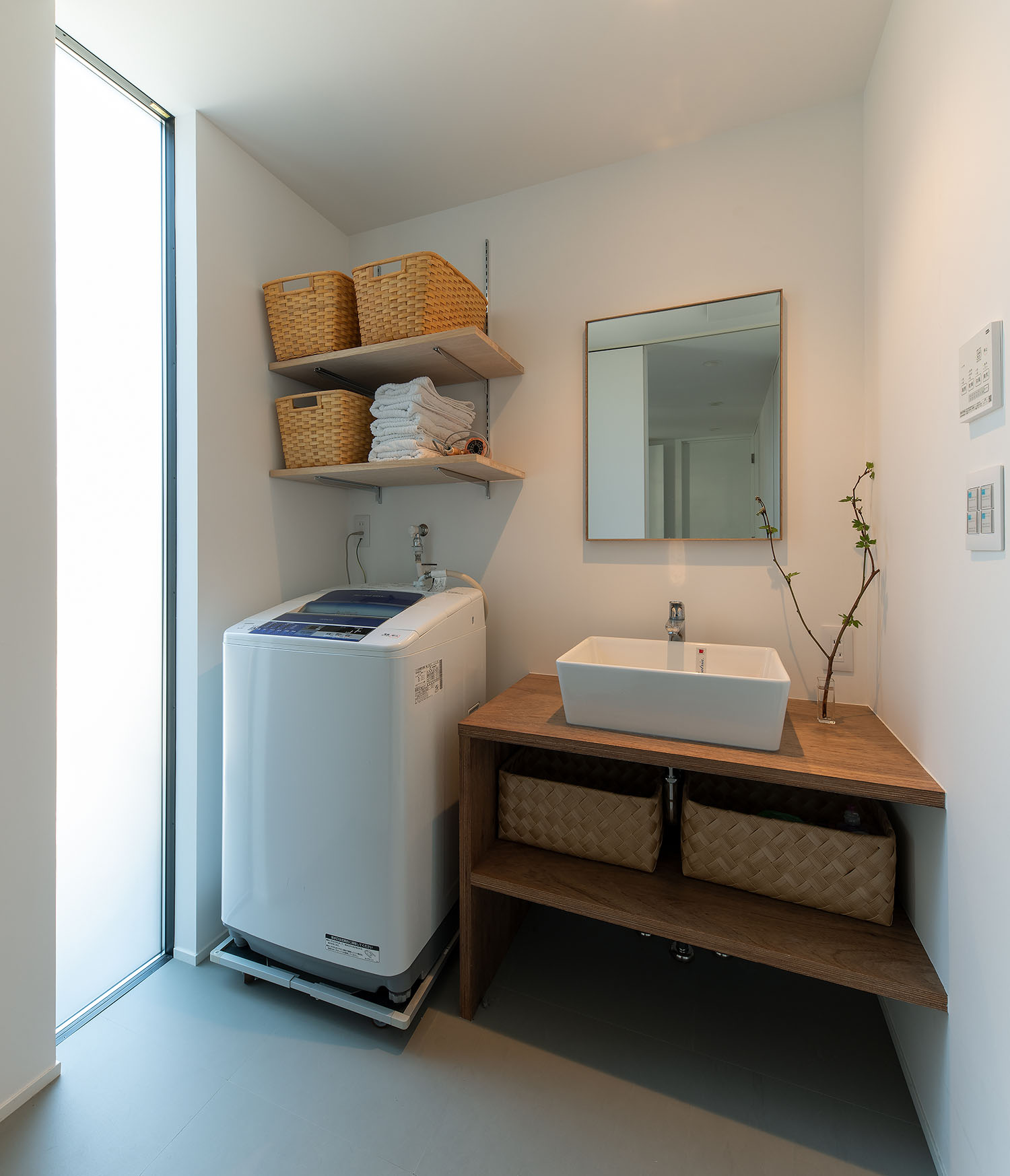 洗面ボウルの隣に洗濯機がある白を基調とした洗面所・デザイン住宅 注文住宅・デザイン住宅建築実例_『CASE687 "□×□×和 (ハコニワ)"』_浴室・洗面所
