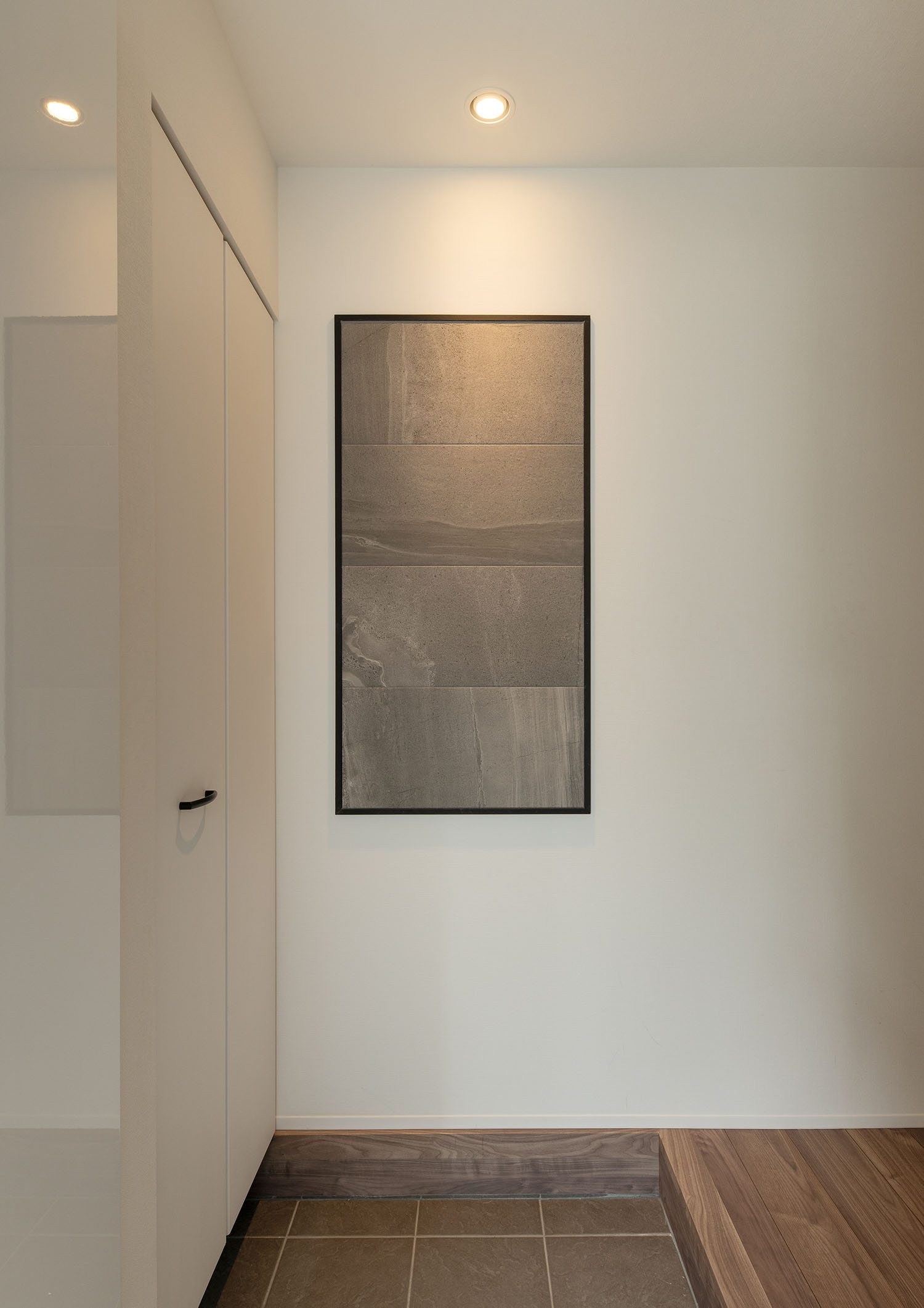 白い壁にグレーのアートが飾られた玄関・デザイン住宅 注文住宅・デザイン住宅建築実例_『CASE689 猫と寄り添う家』_玄関