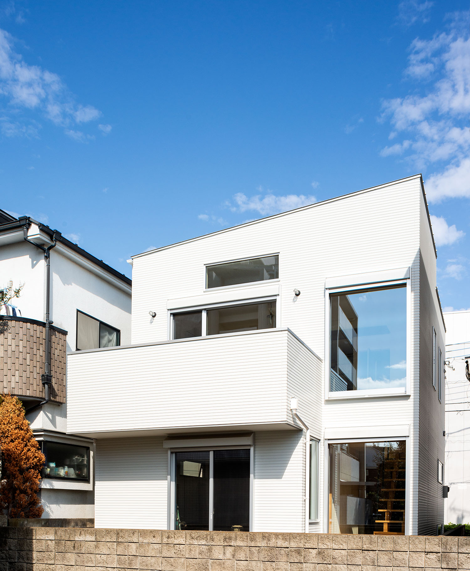 バルコニーや大きな開口部が設けられた白い外壁の住宅・デザイン住宅 注文住宅・デザイン住宅建築実例_『CASE690 質感にこだわった完成を楽しむ家』_外観