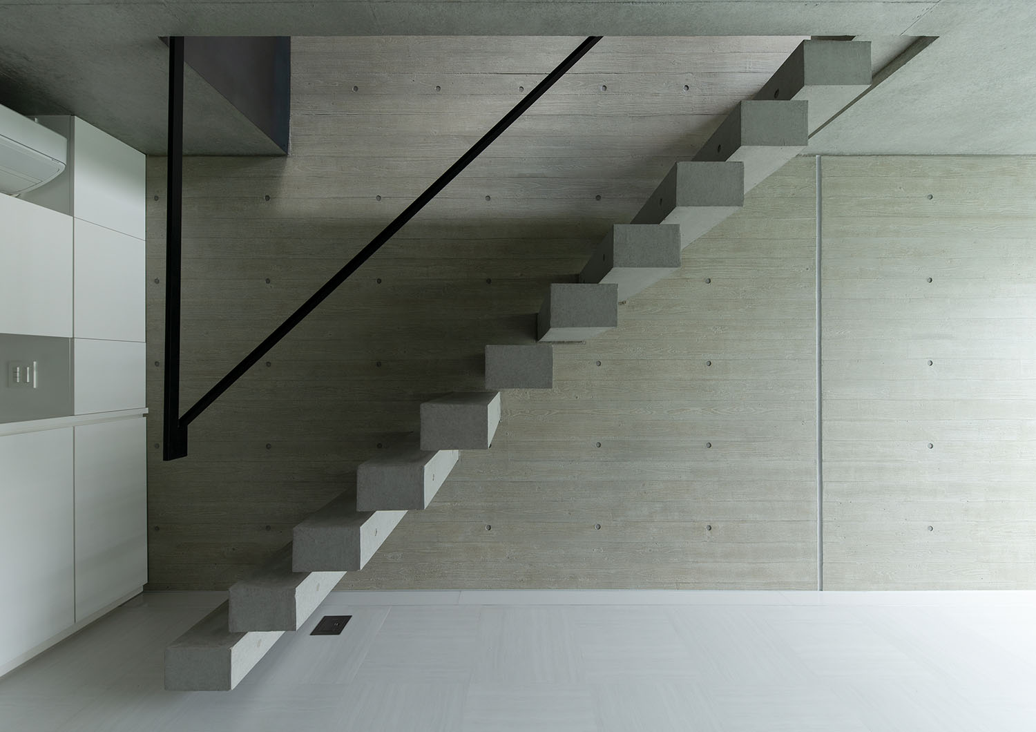 黒い手すりがある浮いたデザインのコンクリートの階段・デザイン住宅 注文住宅・デザイン住宅建築実例_『CASE691 MateriaBox』_階段