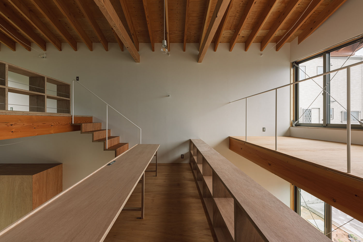 吹き抜けに面したデスクスペースがある梁見せ天井のスキップフロア・デザイン住宅 注文住宅・デザイン住宅建築実例_『CASE692 桜ヶ丘の住宅』_LDK