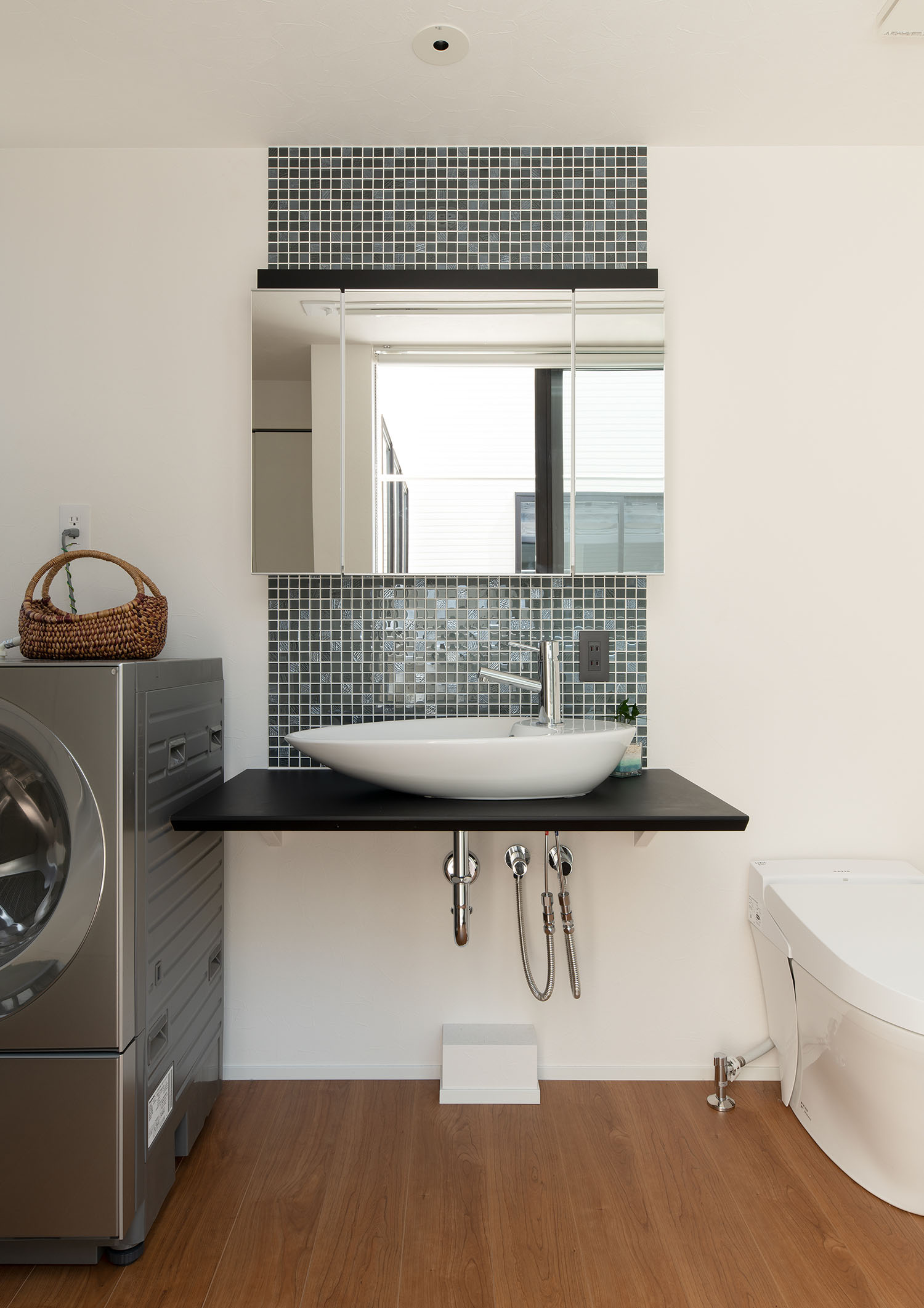 タイルの壁に鏡が取り付けられている洗面所・デザイン住宅 注文住宅・デザイン住宅建築実例_『CASE693 "CONNECT"』_浴室・洗面所