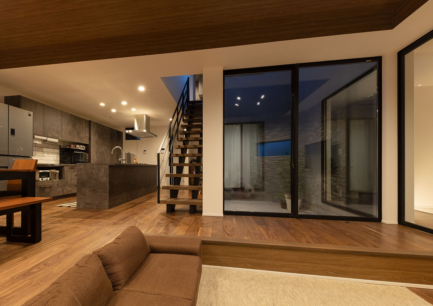 ダウンライトによって照らされるブラウンを基調としたLDK・デザイン住宅 注文住宅・デザイン住宅建築実例_『CASE695 メガホンハウス』_LDK