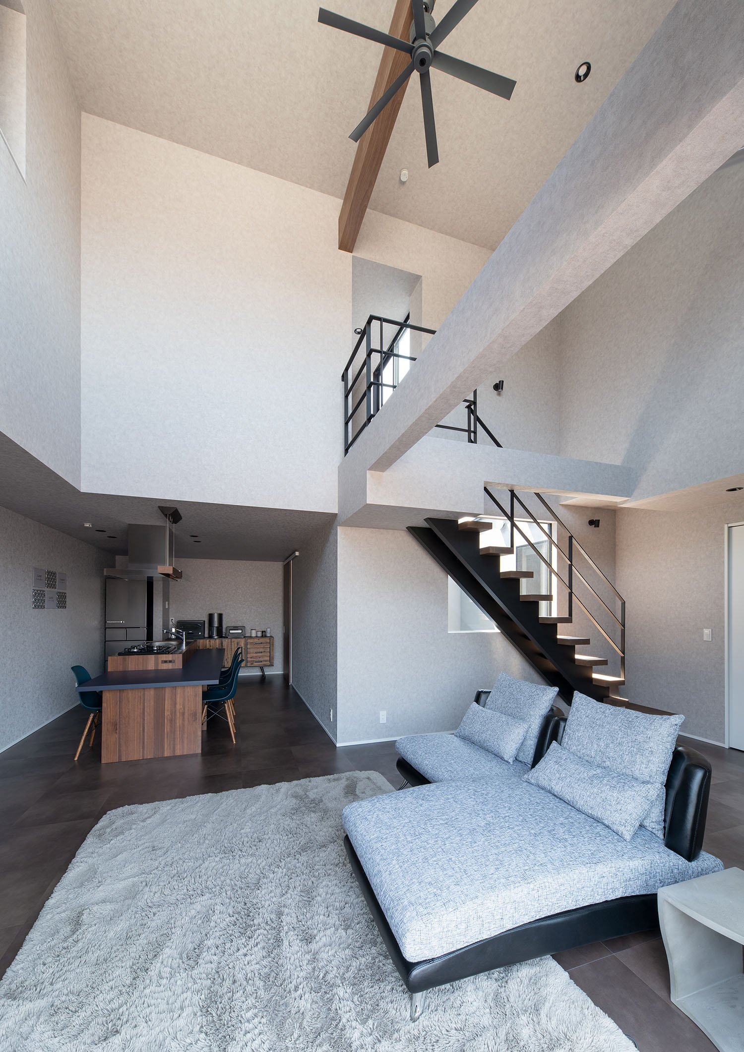 吹き抜け上部にファンが取り付けられた、ソファーのあるLDK・デザイン住宅 注文住宅・デザイン住宅建築実例_『CASE695 メガホンハウス』_LDK