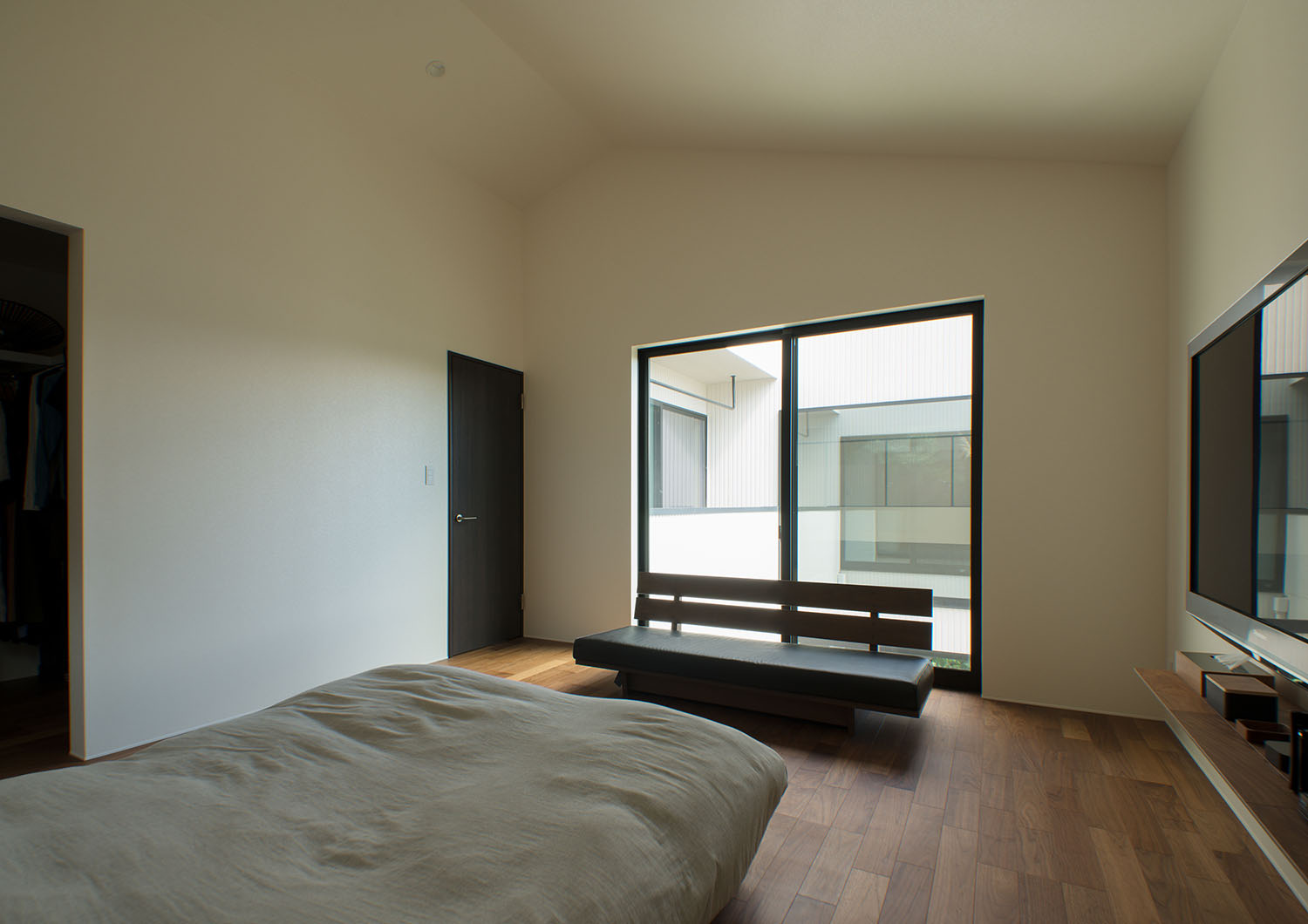 大きな窓の前にソファーが設けられた寝室・デザイン住宅 注文住宅・デザイン住宅建築実例_『CASE696 tongari house』_寝室