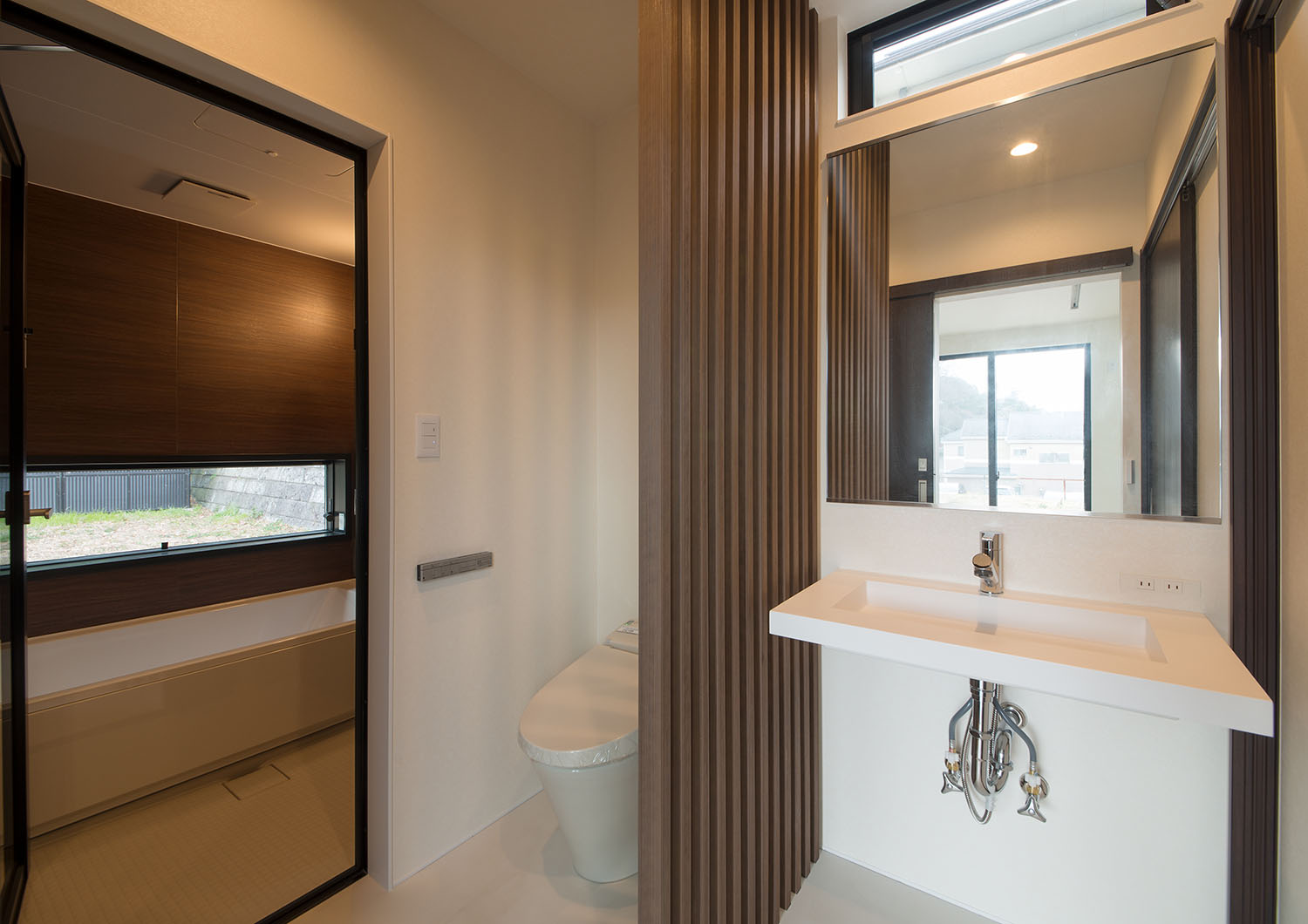 トイレと洗面ボウルの間にルーバーの仕切りがある洗面所・デザイン住宅 注文住宅・デザイン住宅建築実例_『CASE696 tongari house』_浴室・洗面所